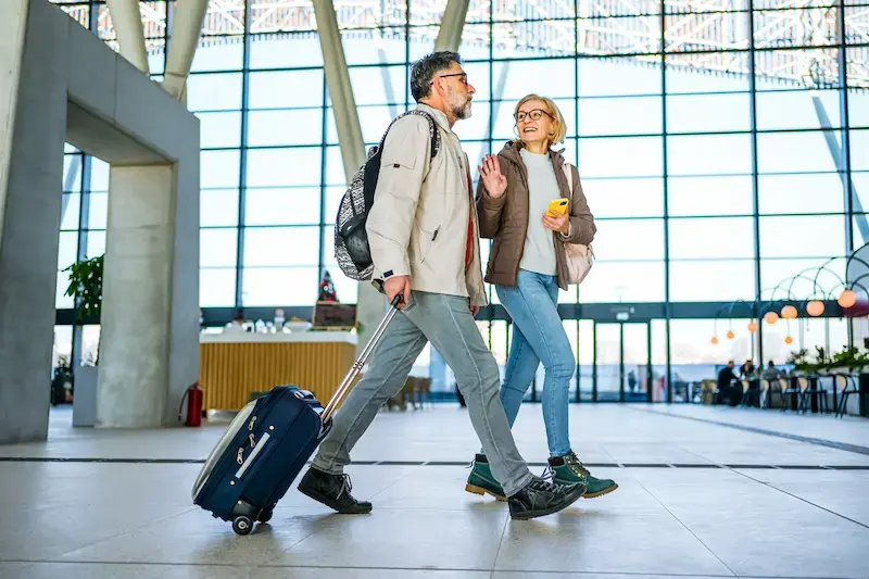 Pareja con maleta caminando por una estación antes de viajar a Canadá 
