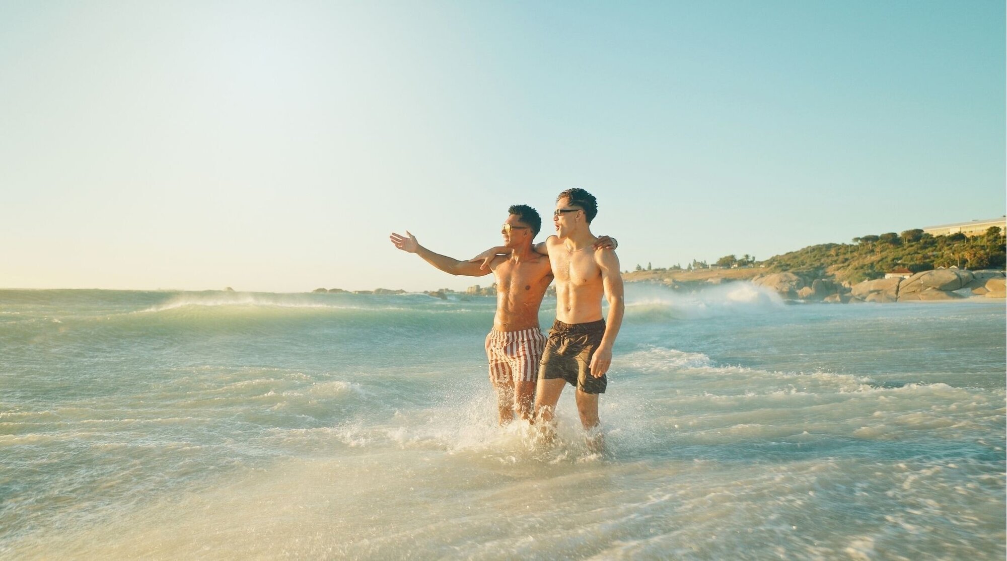 Amigos jugando en el mar, diversión en la playa durante vacaciones.