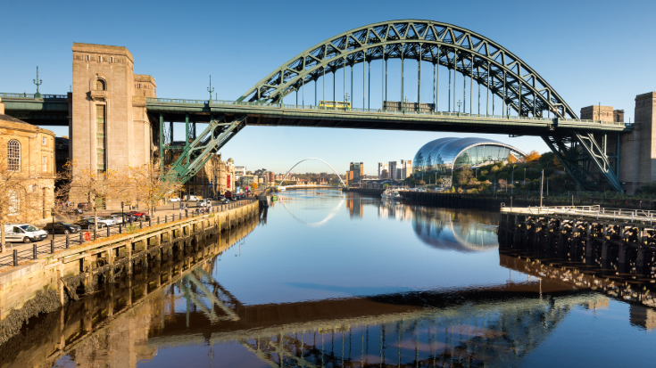 The industrial Tyne bridge, showing Newcastle's urban cityscape in the background.