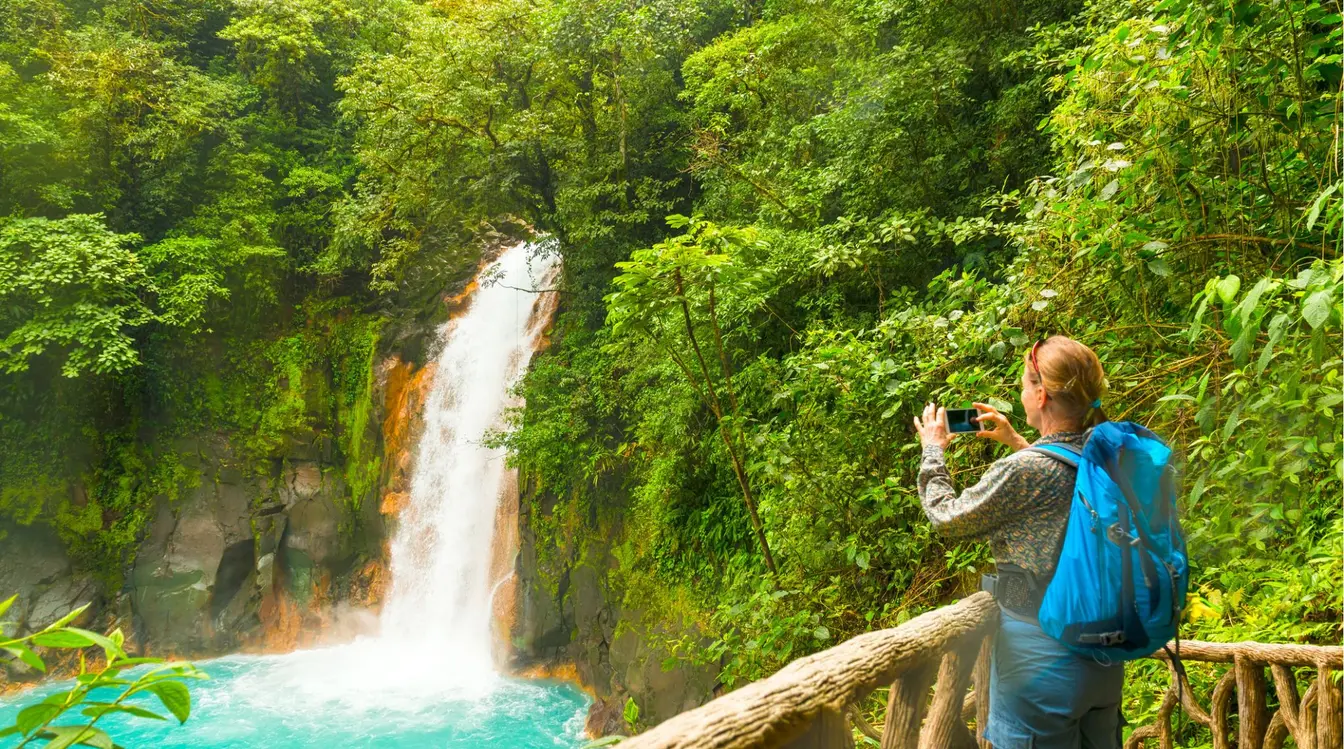 Voyageuse photographiant une rivière dans la forêt tropicale au Costa Rica.
