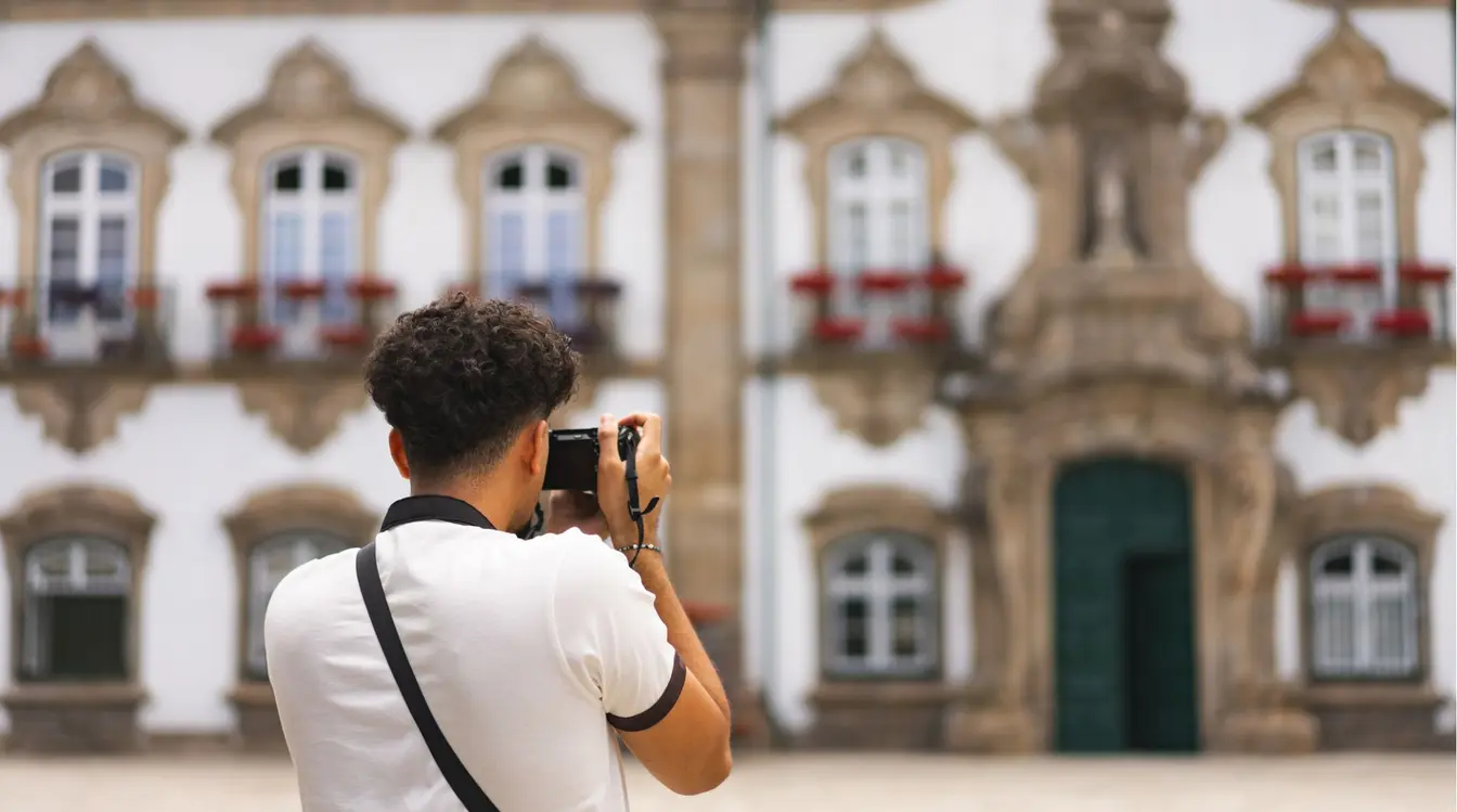 Turista fotografando a fachada barroca da Câmara Municipal de Braga, no centro histórico da cidade, norte de Portugal.