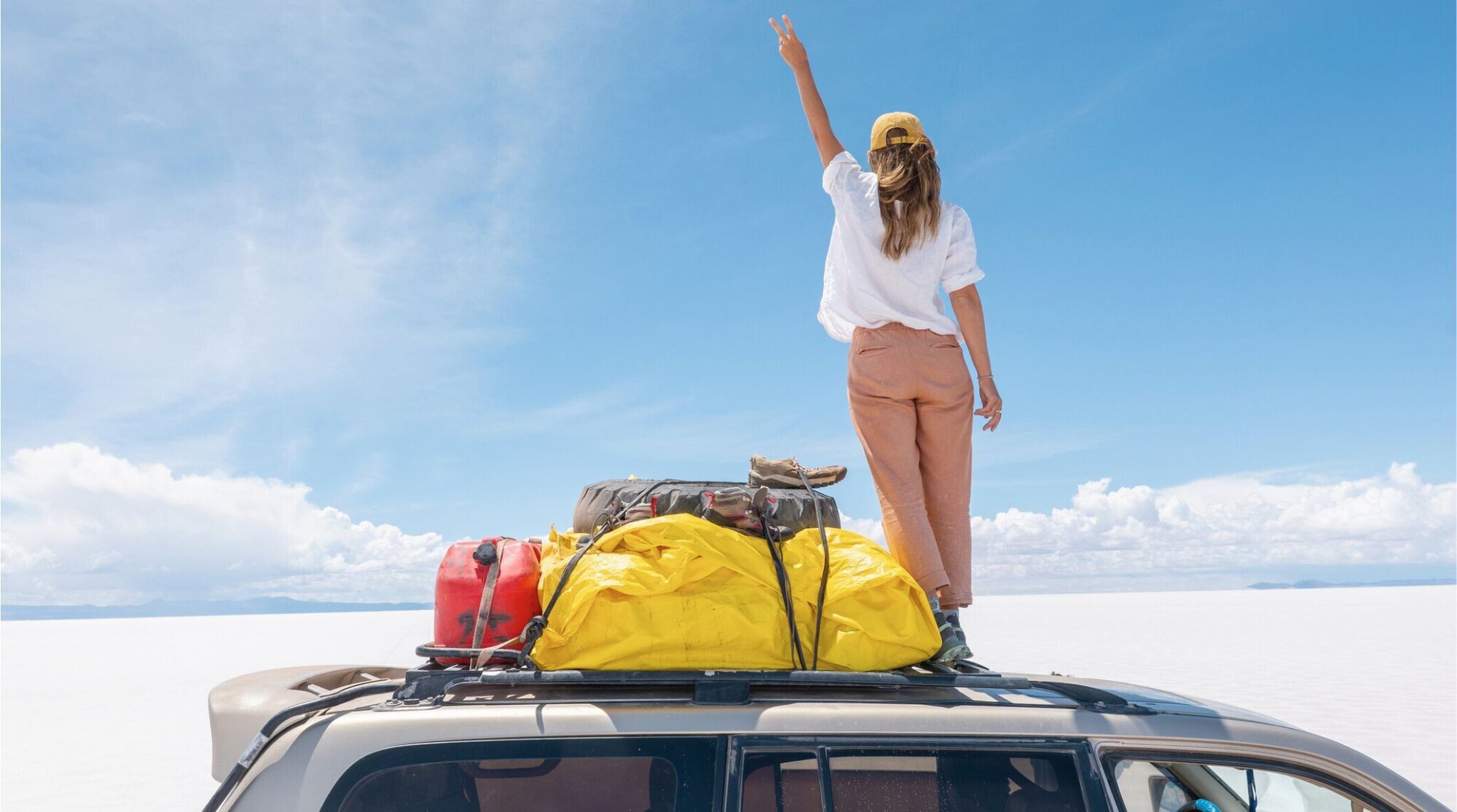 Mulher em cima de um SUV no Salar de Uyuni.