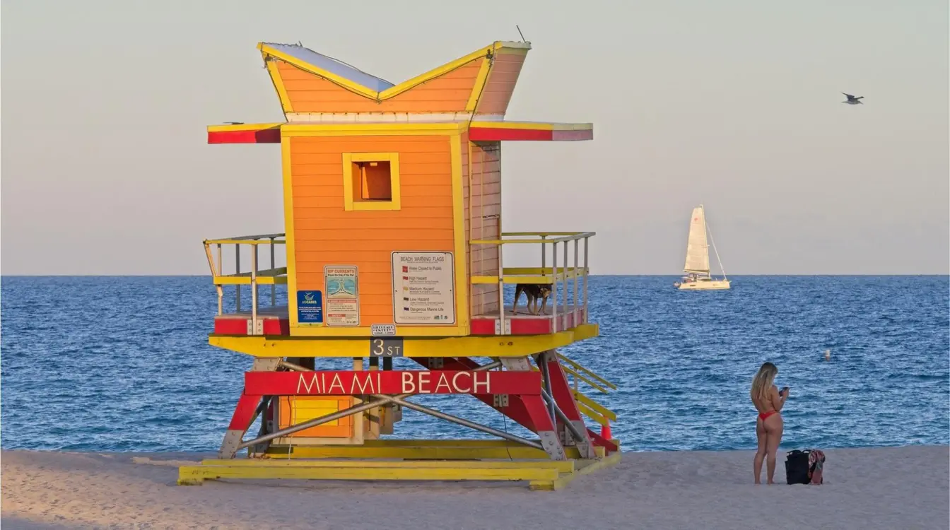 Cabana colorida de salva-vidas de Miami Beach na praia do sul no final do dia, com clima agradável, céu claro e mar azul vibrante.