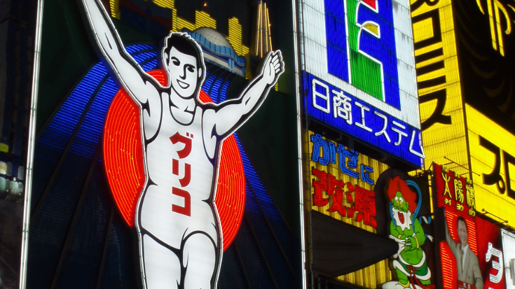 The famous Dotonbori district in Osaka at night, with its glowing neon signs and lively atmosphere, highlighting a must-see location for travelers with a Japanese eSIM.