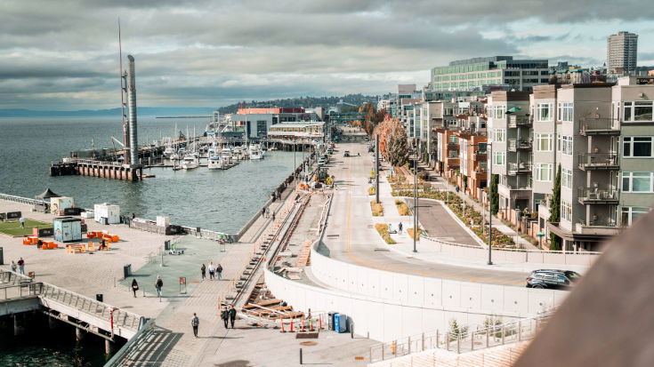 A photograph of Seattle’s waterfront near Pike Place, a popular stop for visitors heading to PAX West - you can see the city's skyline against grey clouds on an overcast day - travellers can explore the city and the PAX event with seamless data from an eSIM USA.