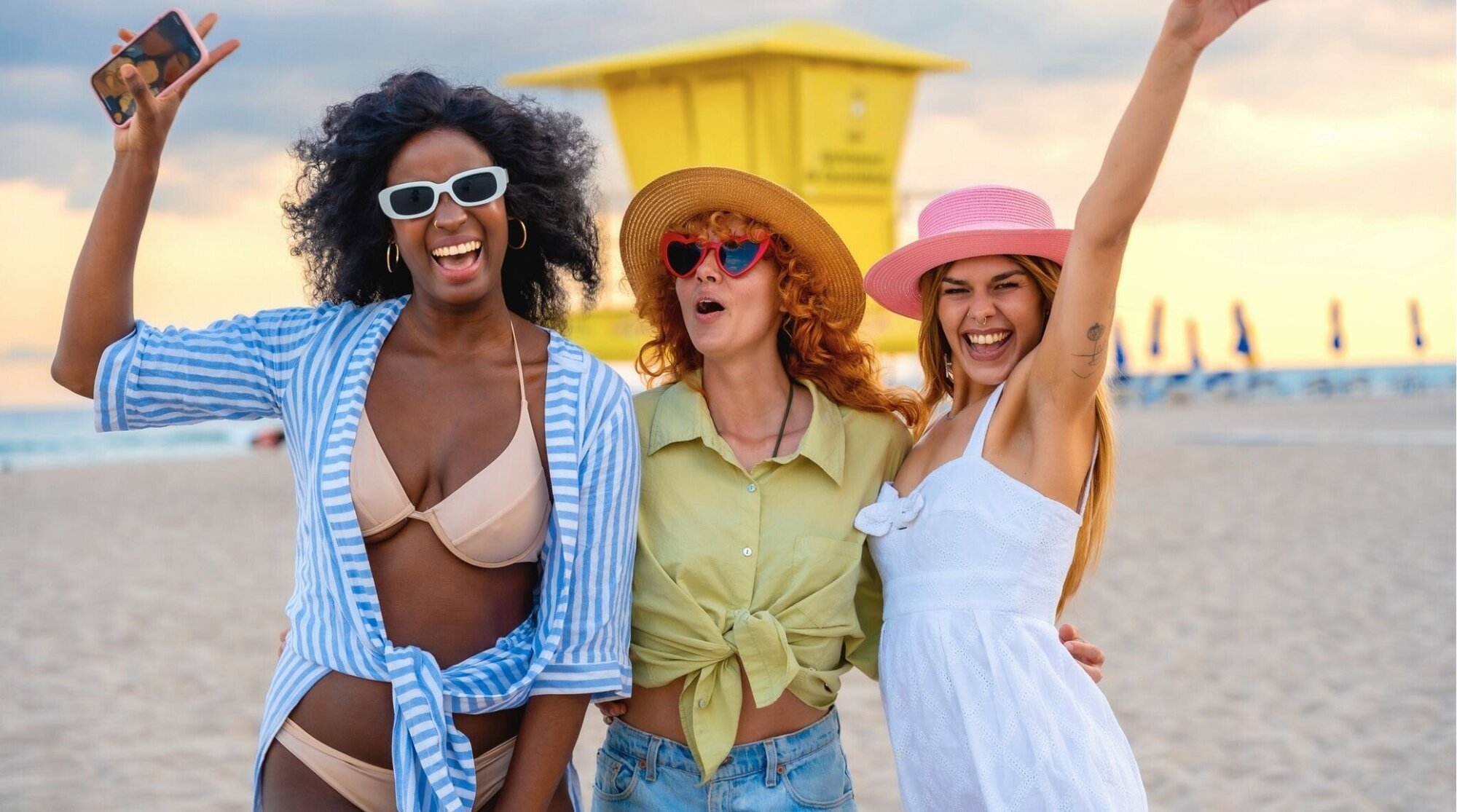 Tres amigas haciéndose un selfie al atardecer en la playa, vibes de Spring Break.