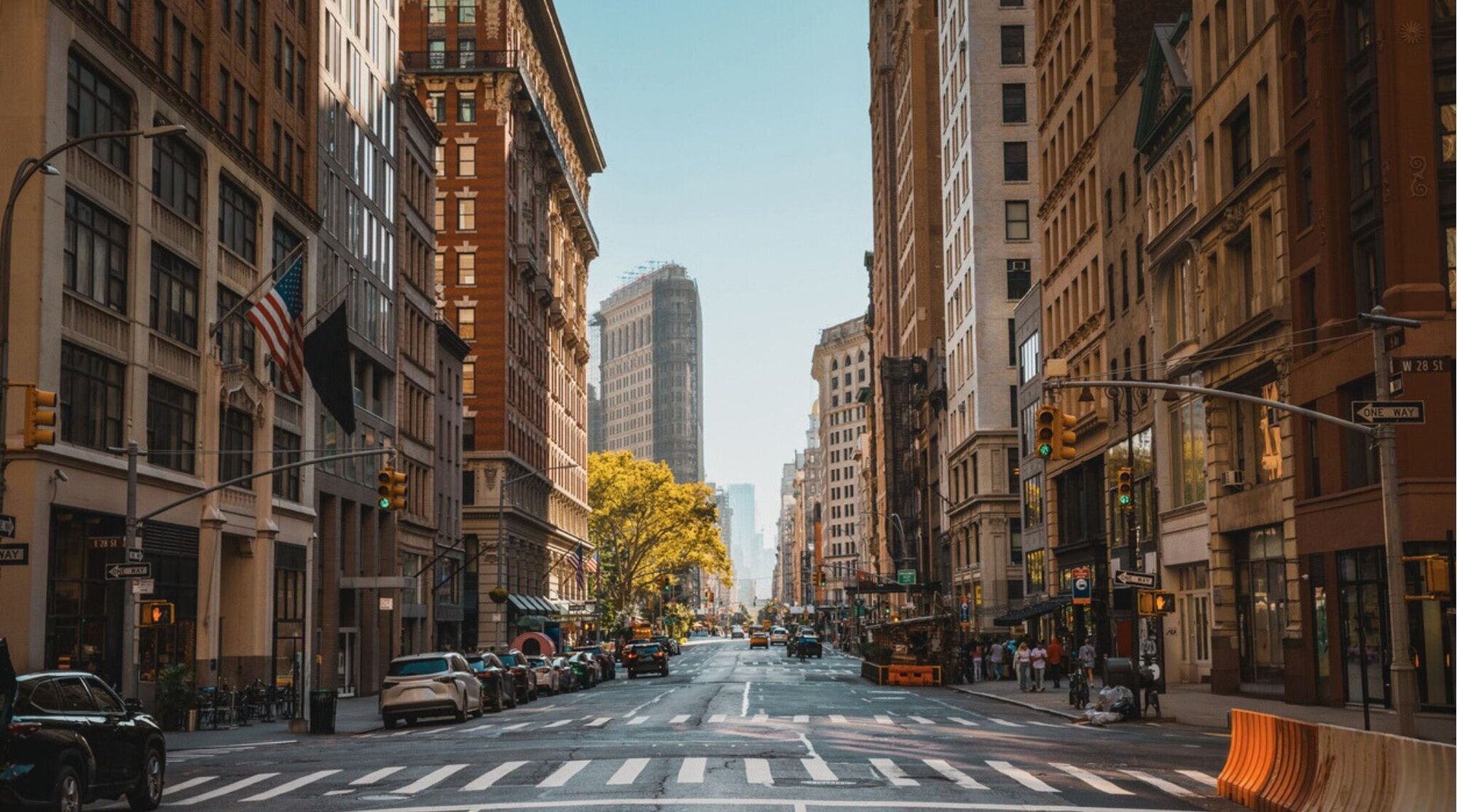 Escena urbana en un cruce peatonal de Nueva York con personas caminando entre rascacielos.