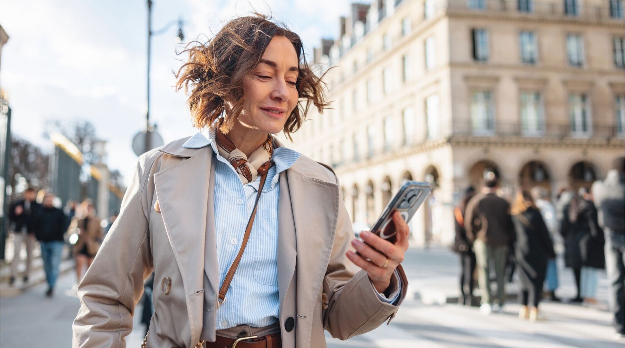 Mulher madura usando celular nas ruas de Paris.