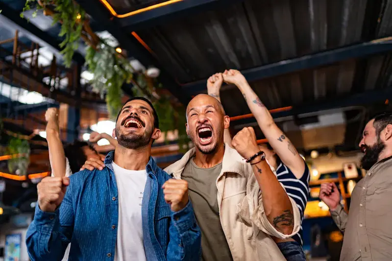 Amigos celebrando un partido de fútbol en un bar durante el verano en Canadá
