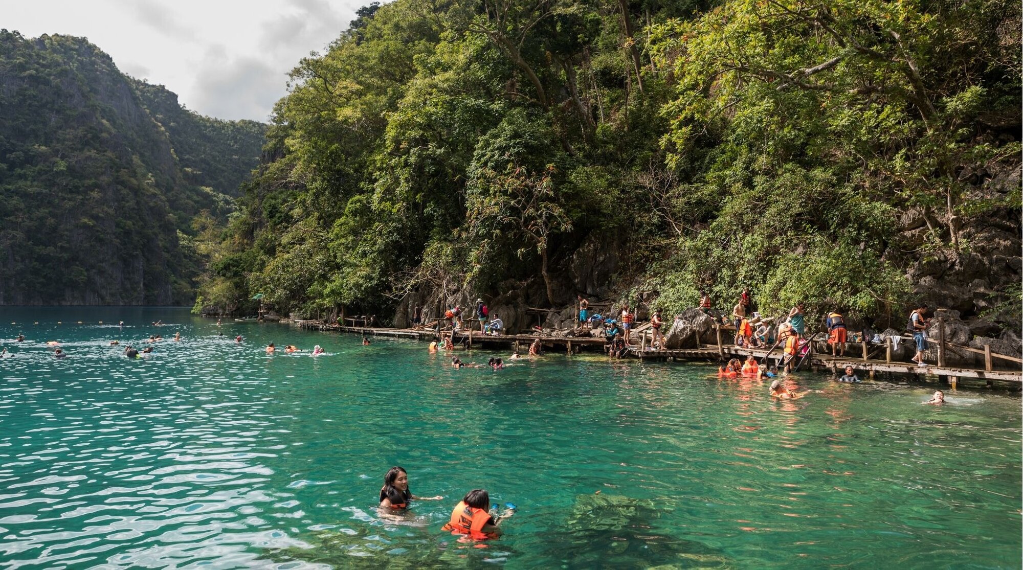 Lago Kayangan na Ilha Coron. Pessoas estão nadando na água cristalina do lago.