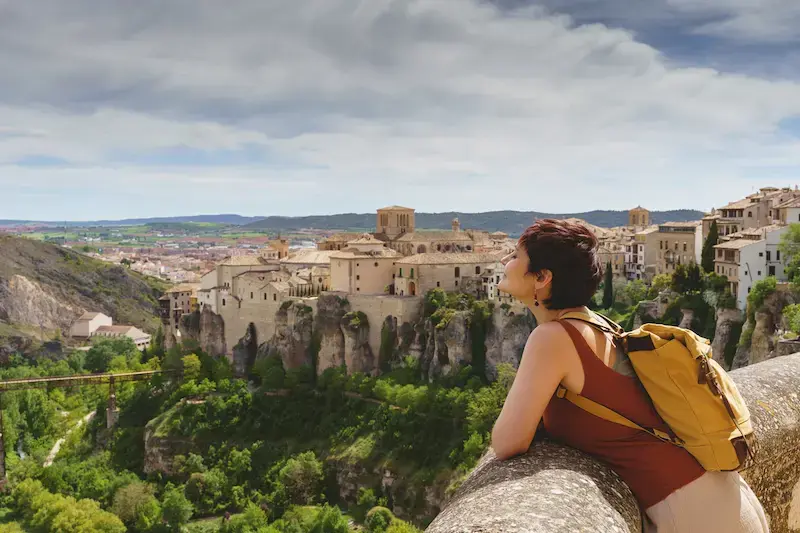 Viajera disfrutando de la vista de una ciudad histórica en España desde un mirador.