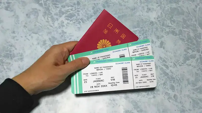 航空券と日本のパスポートを持った男性の手