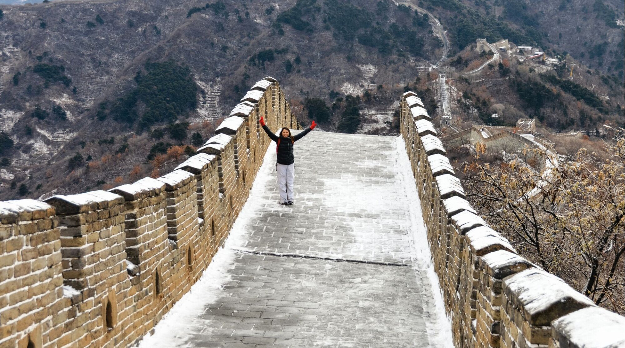 Jovem mulher na Grande Muralha da China com neve.
