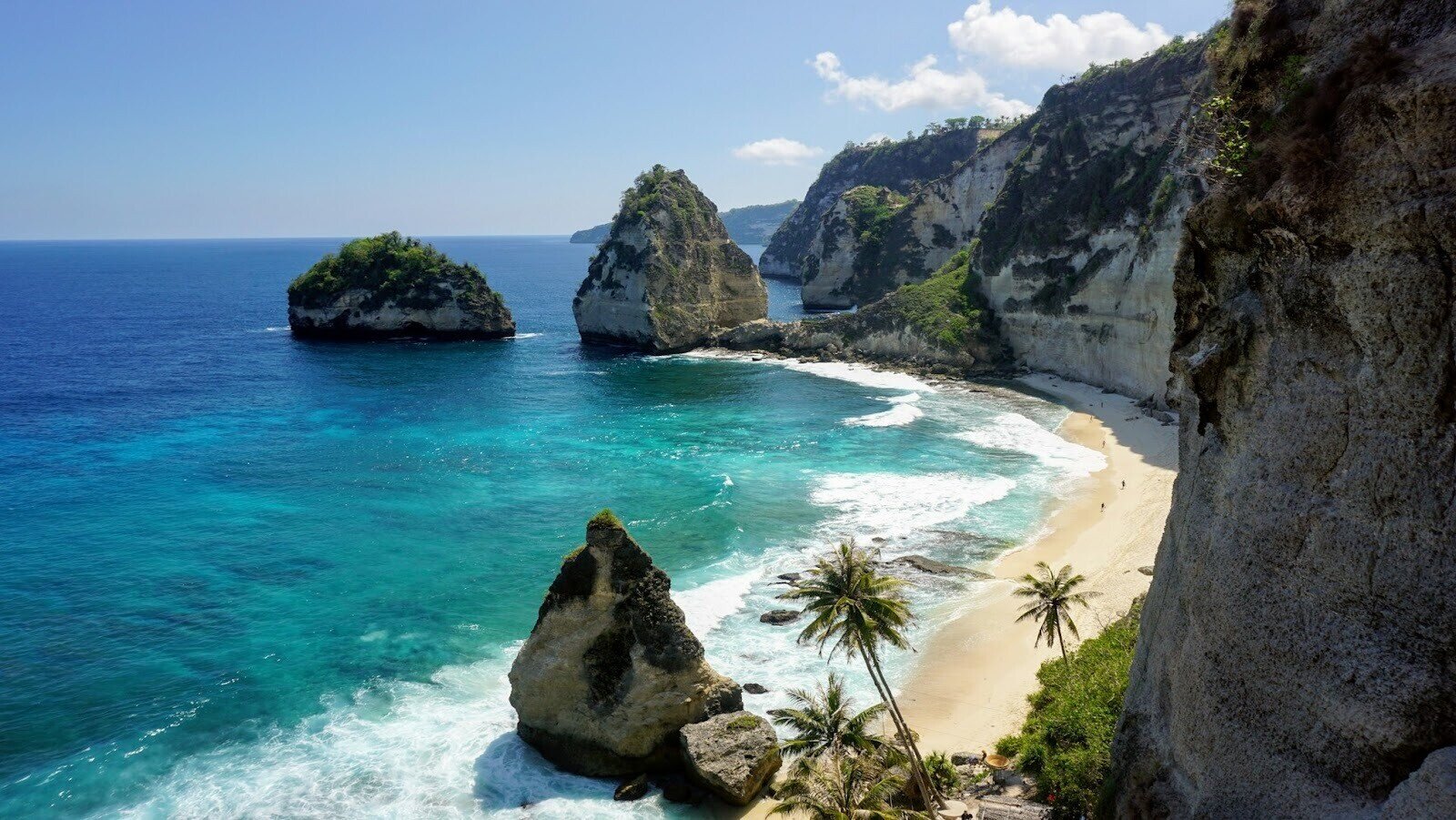 Beach with turquoise body of water surrounded by mountains 