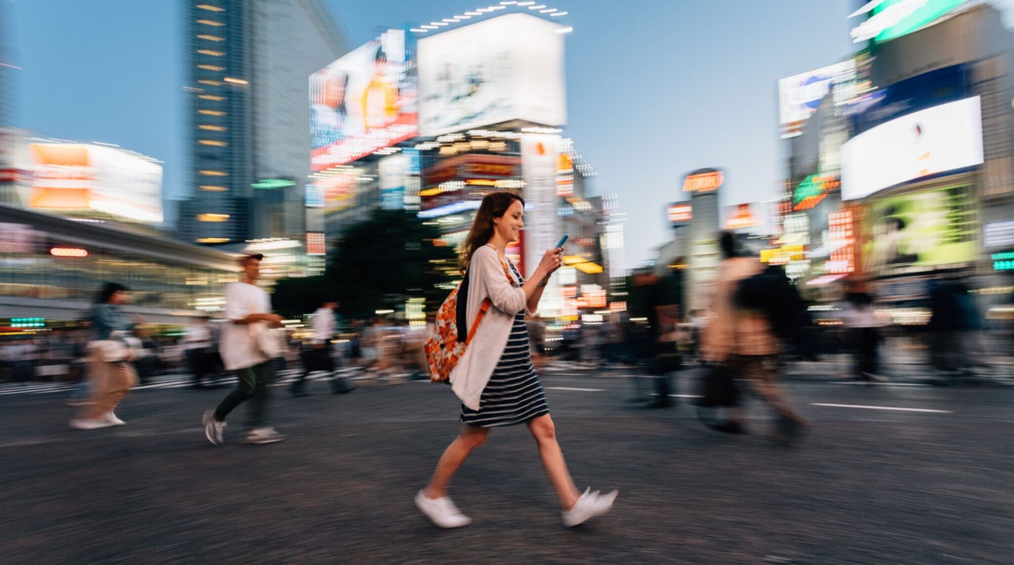 femme en voyage a tokyo avec son telephone equipé d'une eSIM dans la main 