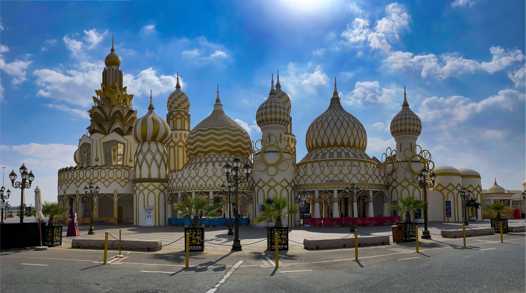  واجهة أحد الأجنحة الشهيرة في القرية العالمية دبي بتصميم القباب الذهبية والزخارف المميزة تحت سماء صافية