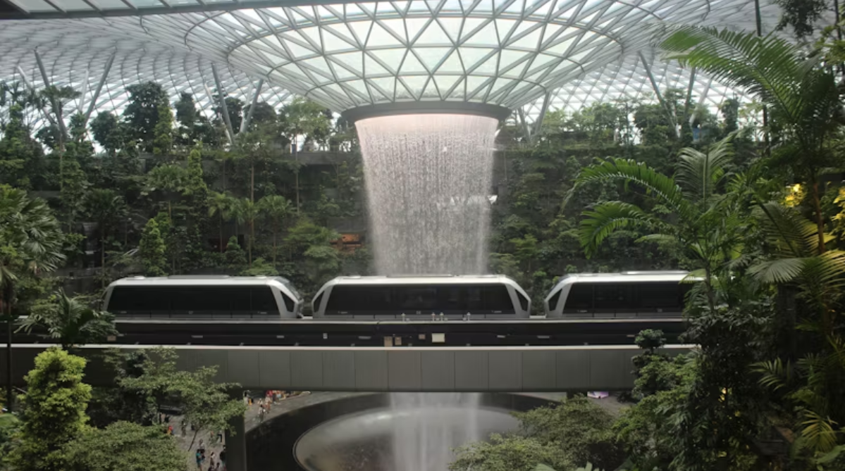 Changi Airport’s Skytrain passing by the indoor waterfall at Jewel Changi Airport