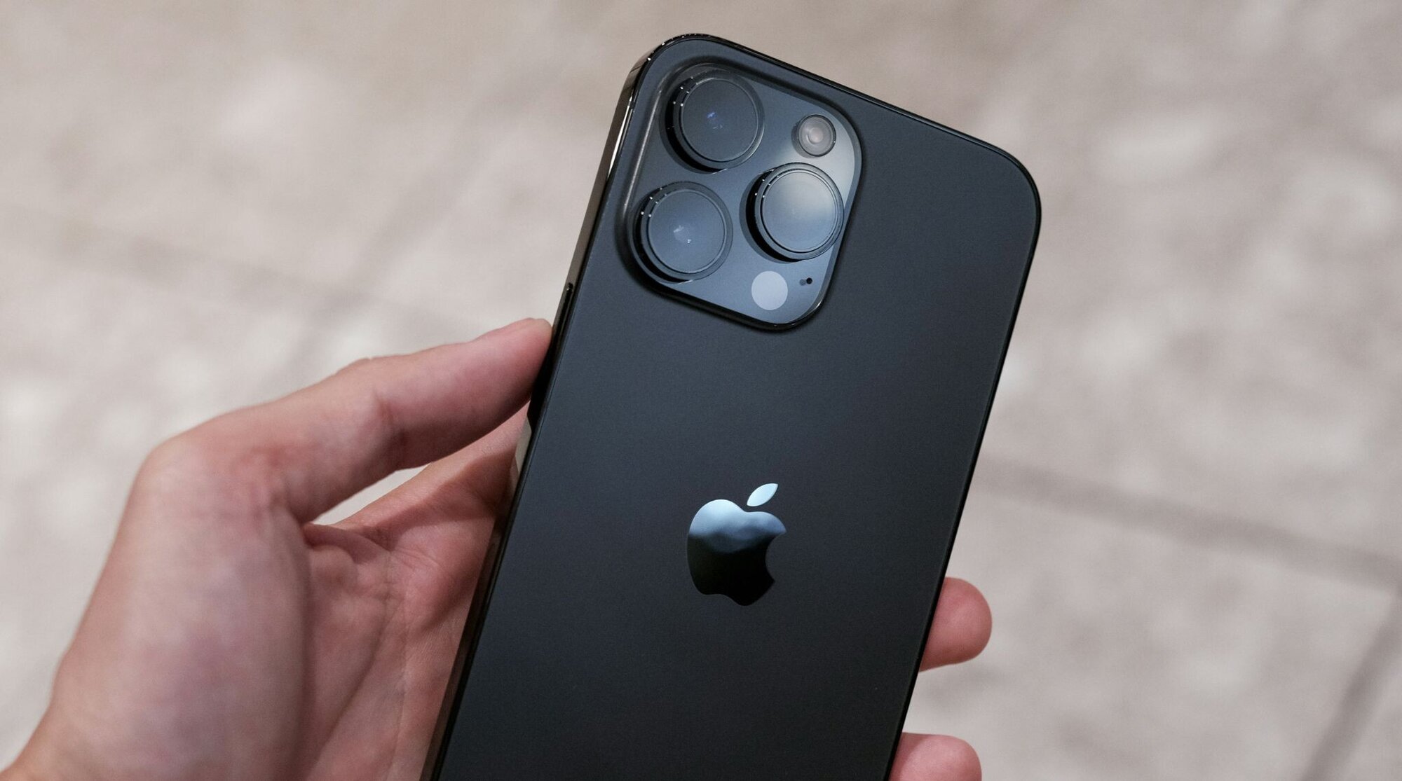 personne tenant un iphone 14 pro max en se demandant s'il est desimlocké