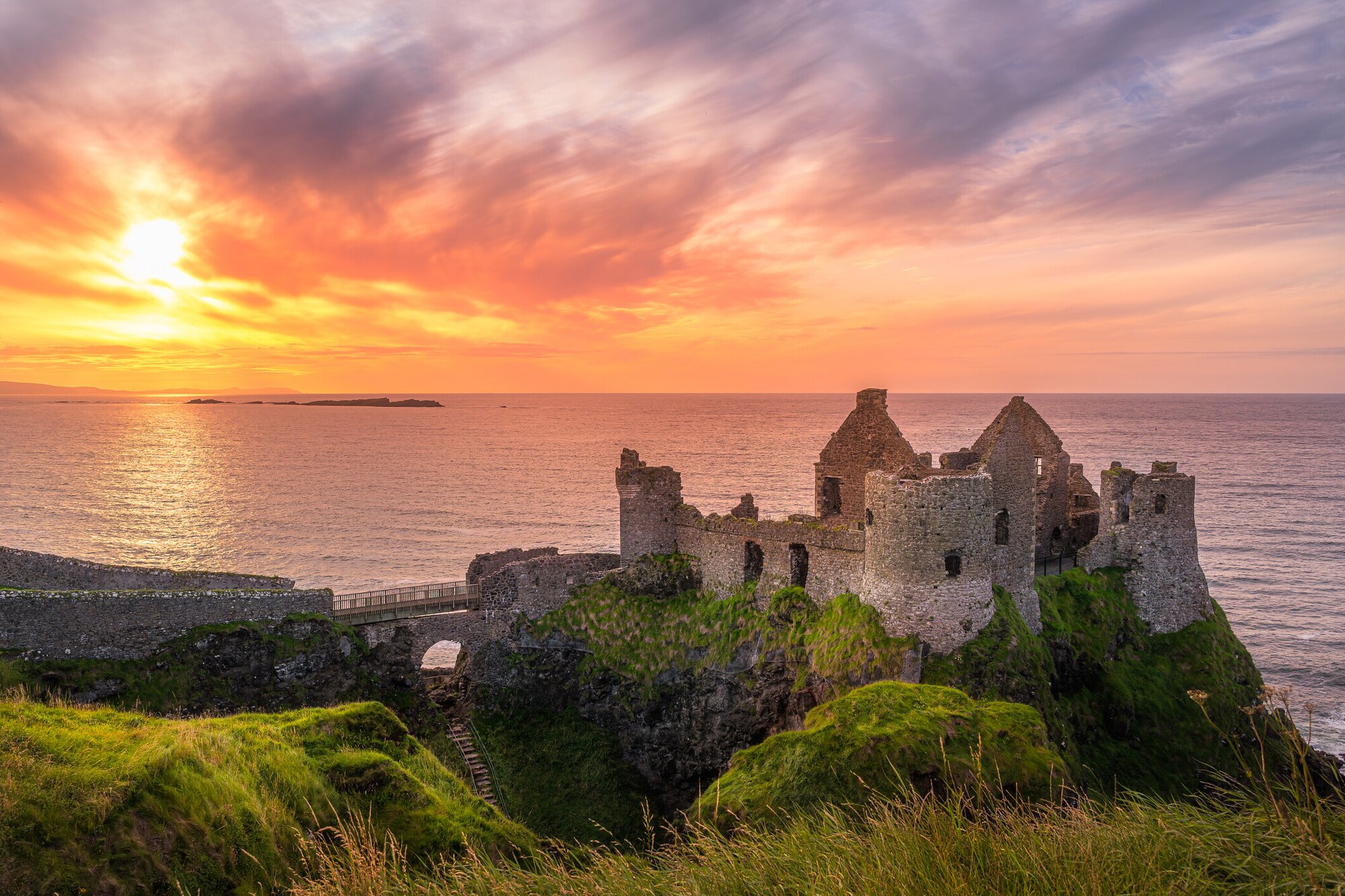 Dunluce Castle in Ireland, a Game of Thrones filming location, with the sunset in the background
