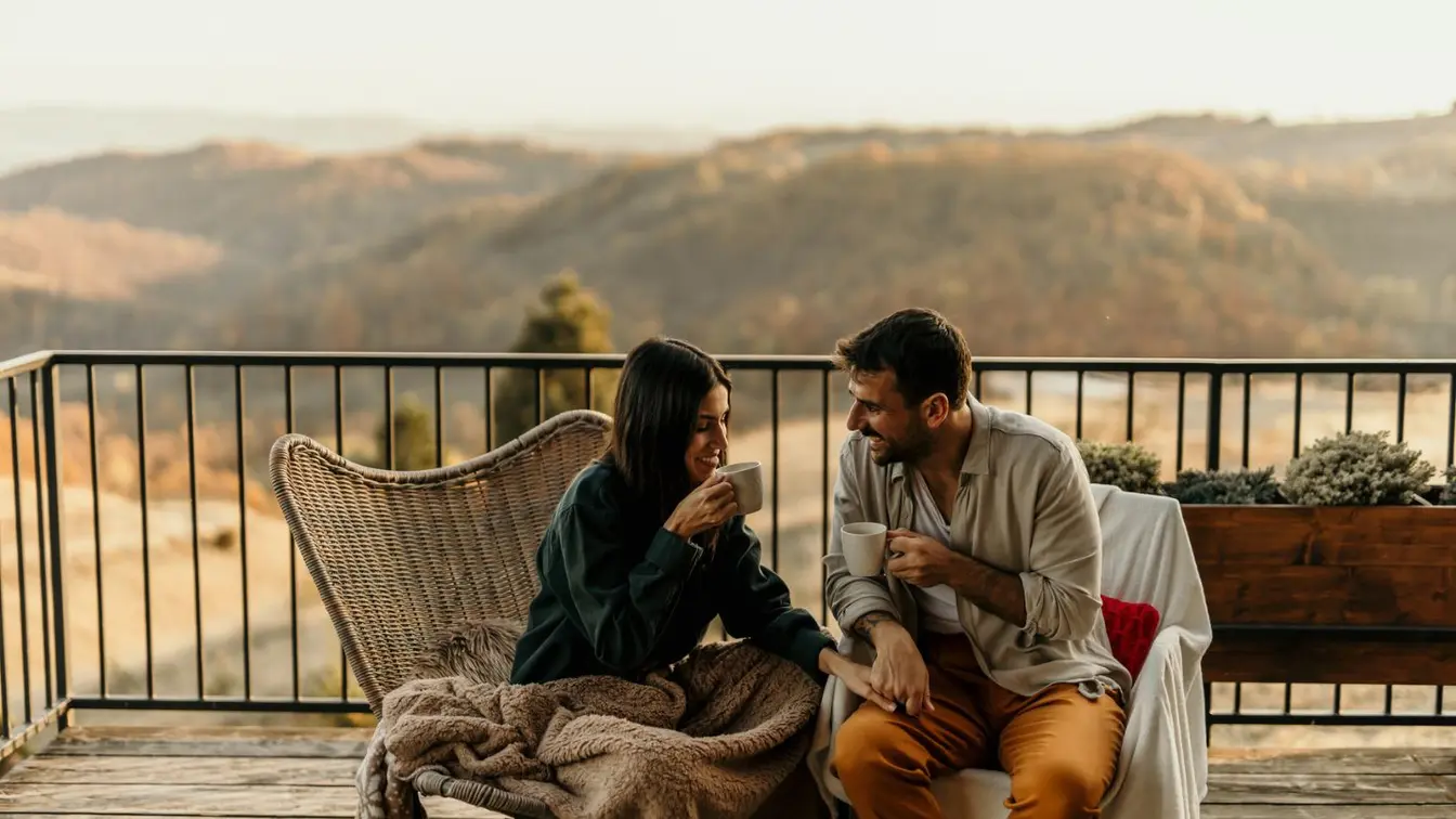 Ein Paar sitzt bei einem romantischen Urlaub auf einer Veranda