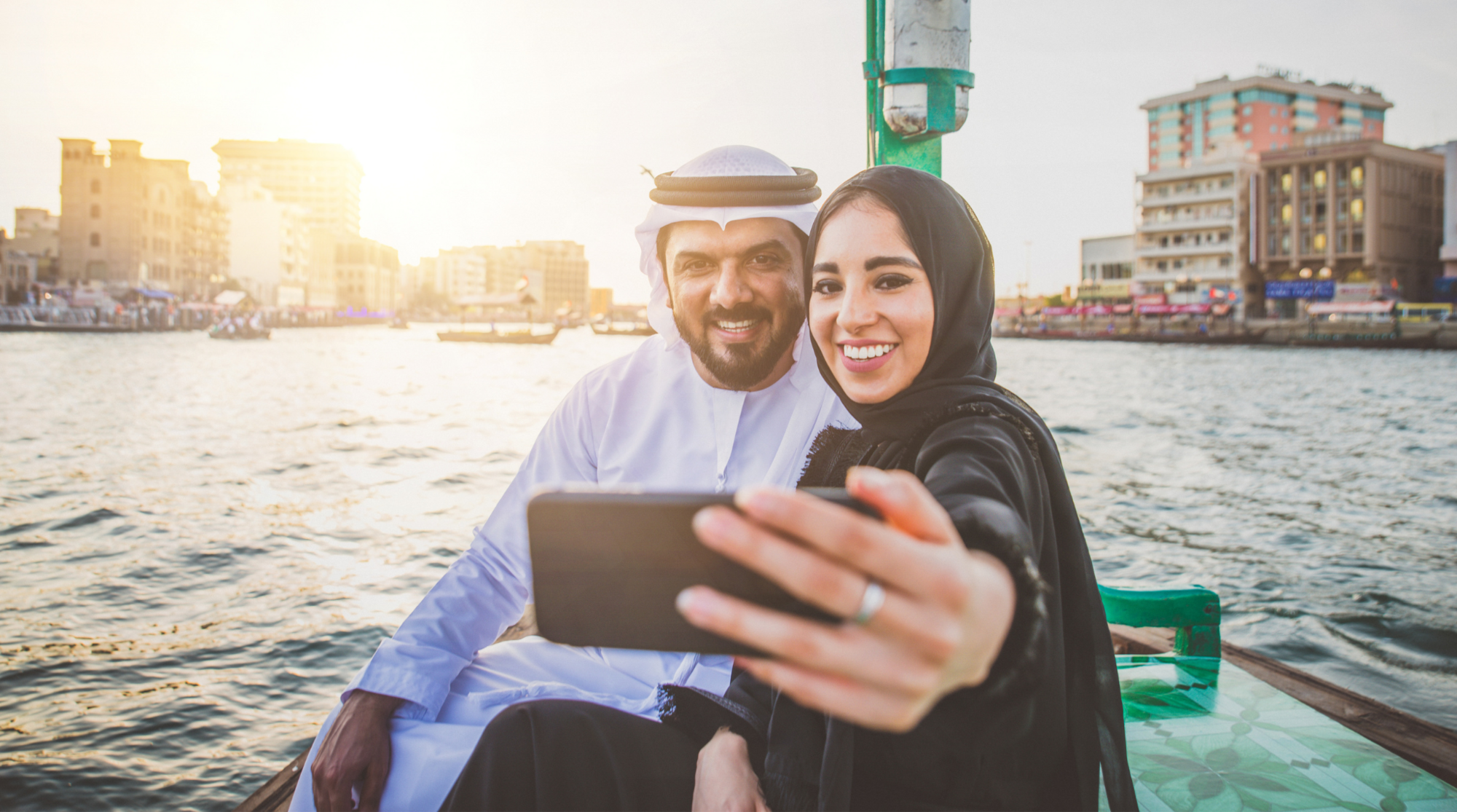 Mann und Frau sitzen in Ägypten auf einem Boot mit Handy in der Hand
