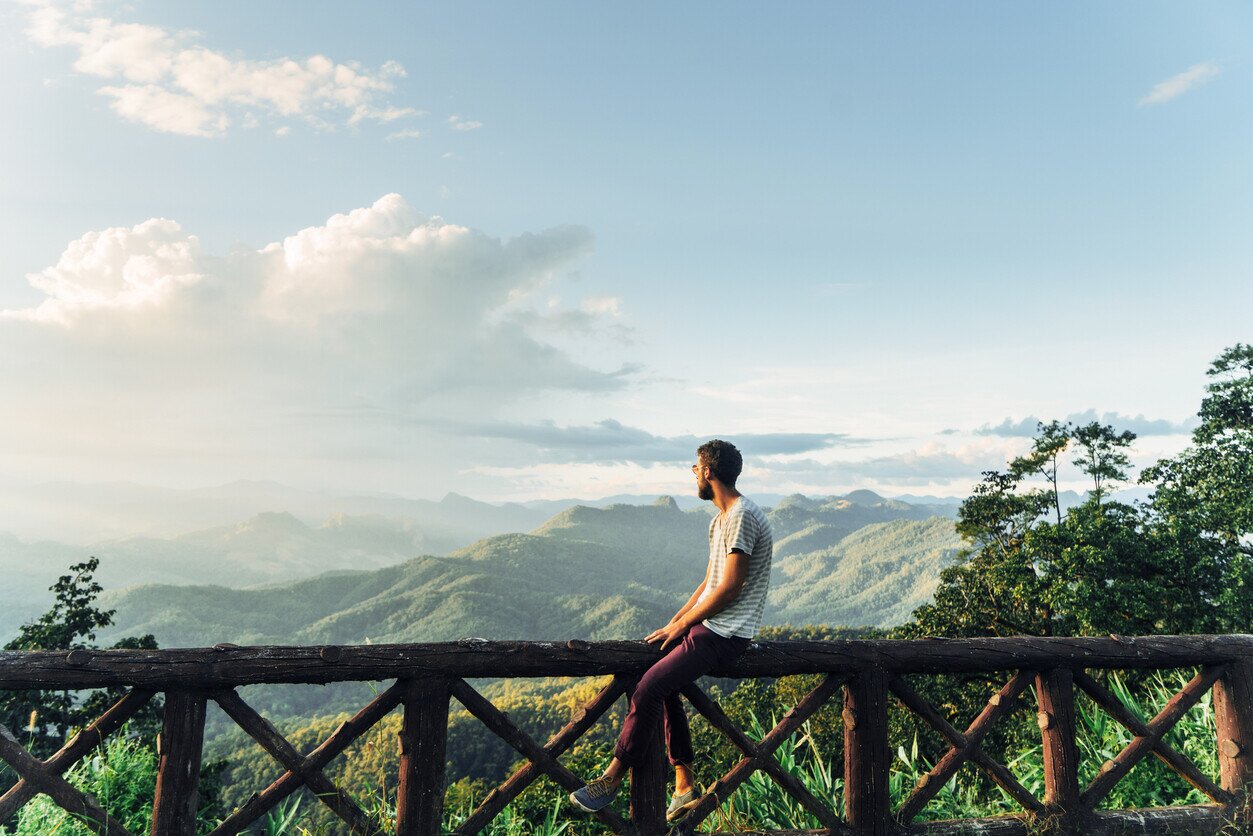 Mann sitzt und genießt die Aussicht auf den Dschungel in Thailand