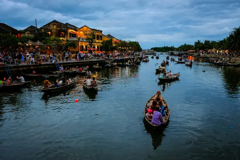 Persone su barche a remi tradizionali in Vietnam per vacanze low cost agosto
