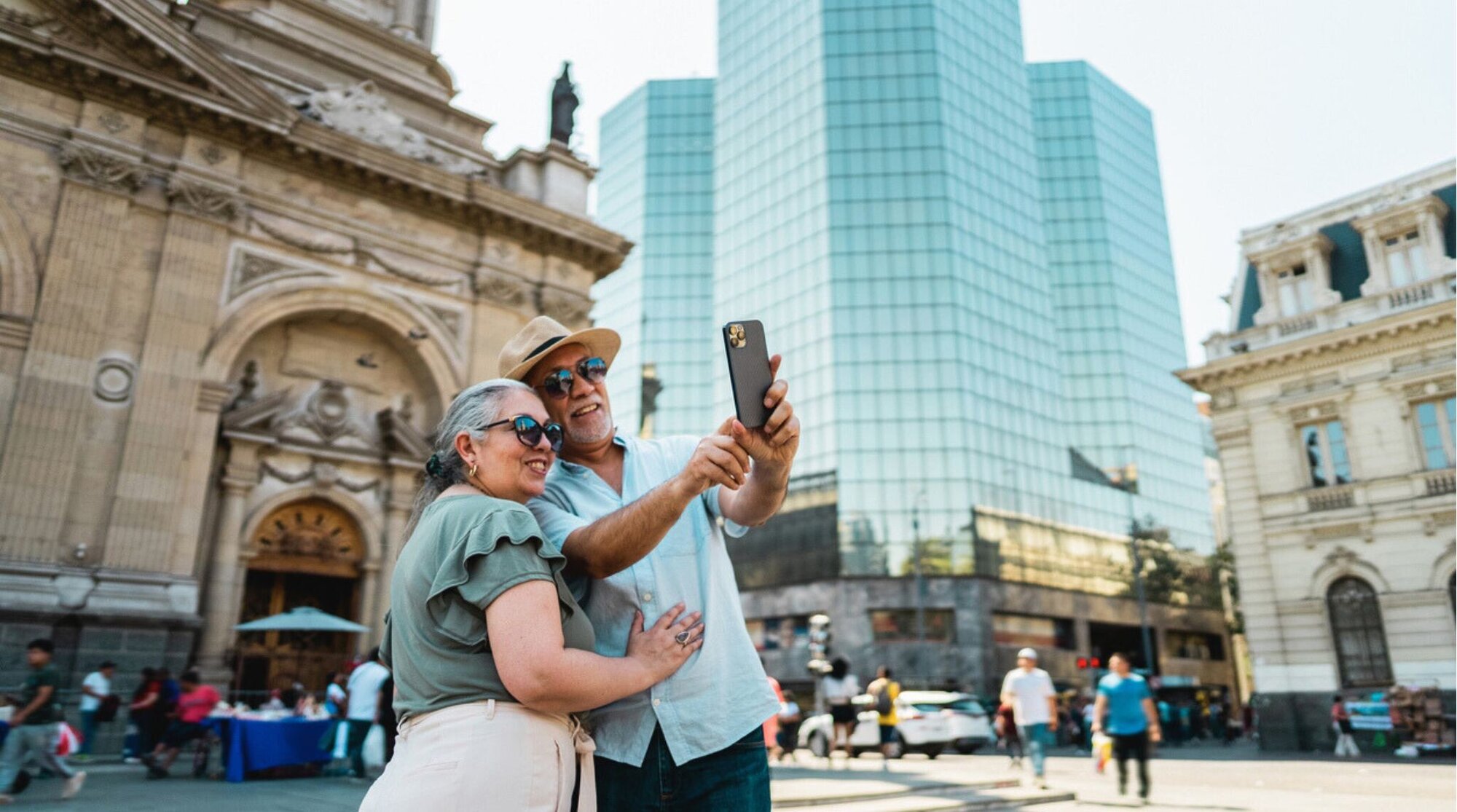 Casal de adultos tirando selfies nas ruas de Santiago, Chile.
