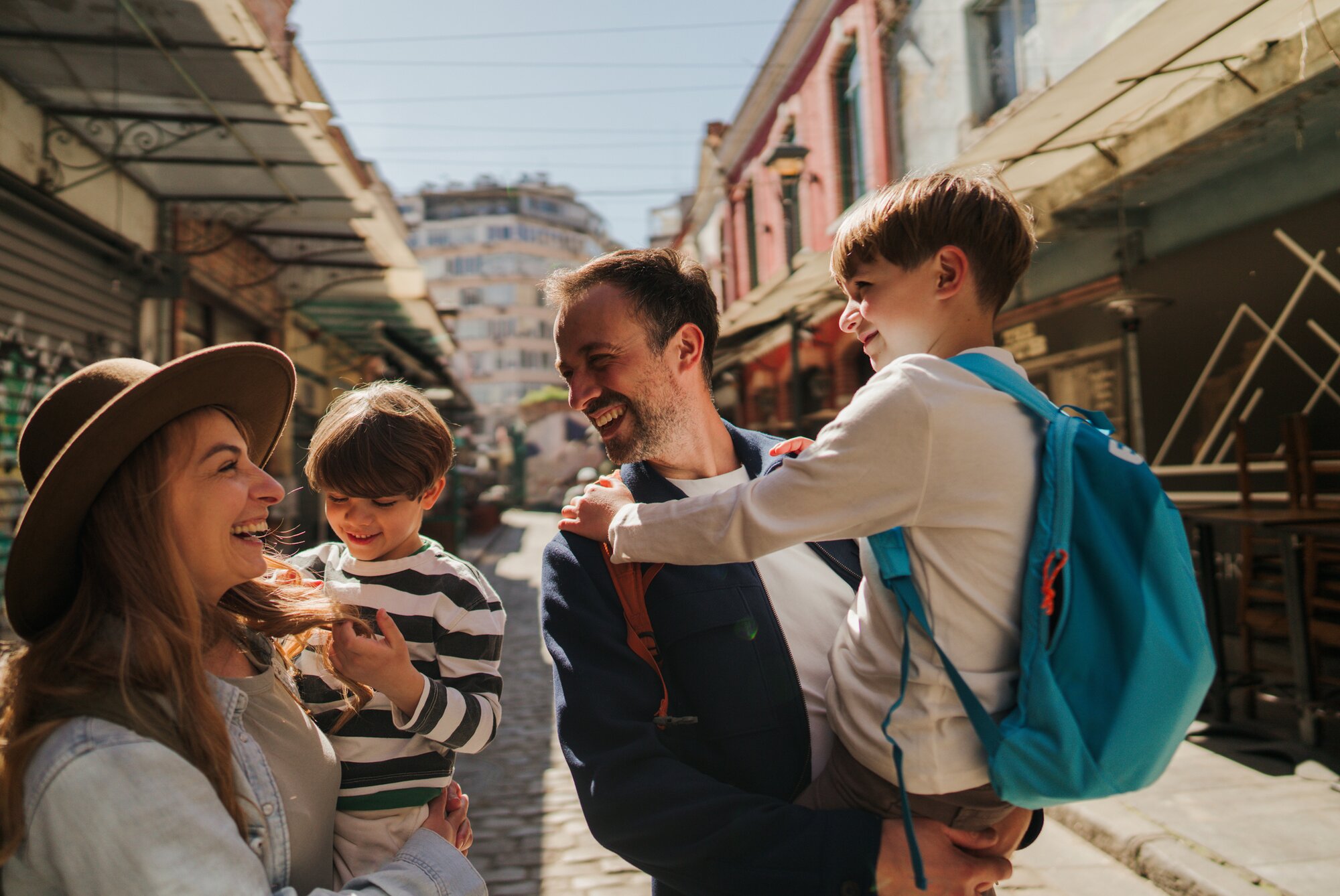 Famiglia che passeggia in una città in Grecia durante viaggi per famiglie tra mare e centri storici