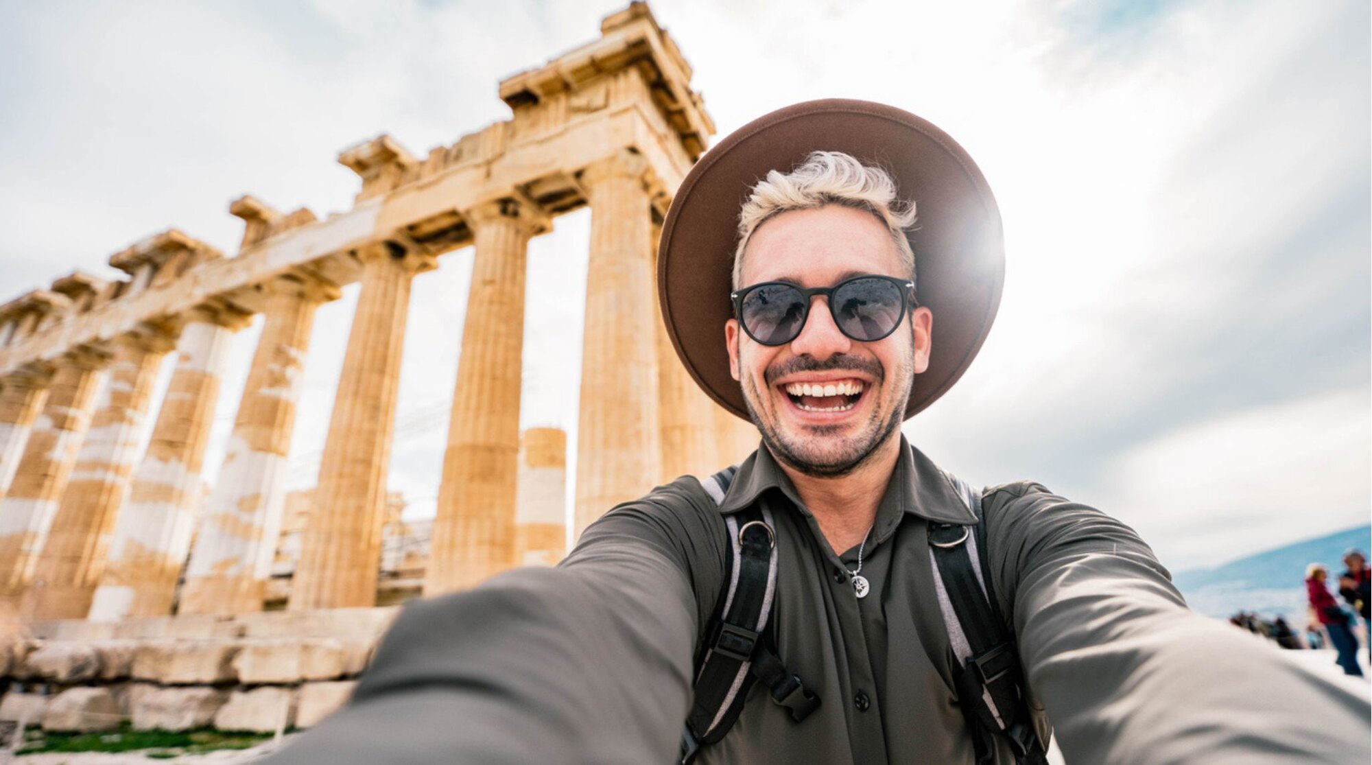 Voyageur français utilisant son téléphone devant l’Acropole d’Athènes en Grèce