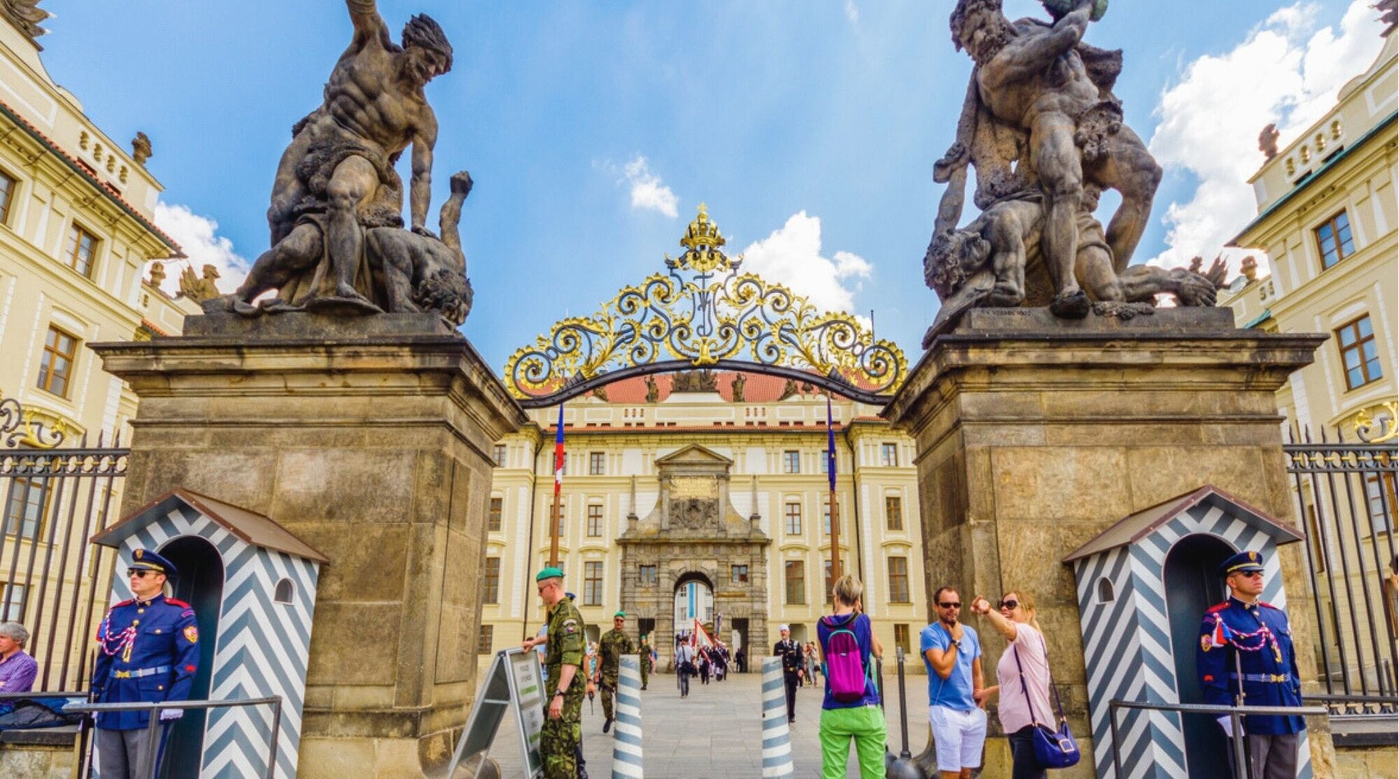 Turistas em frente ao Portão dos Gigantes (também chamado de Gigantes em Combate) no Castelo de Praga, República Tcheca.