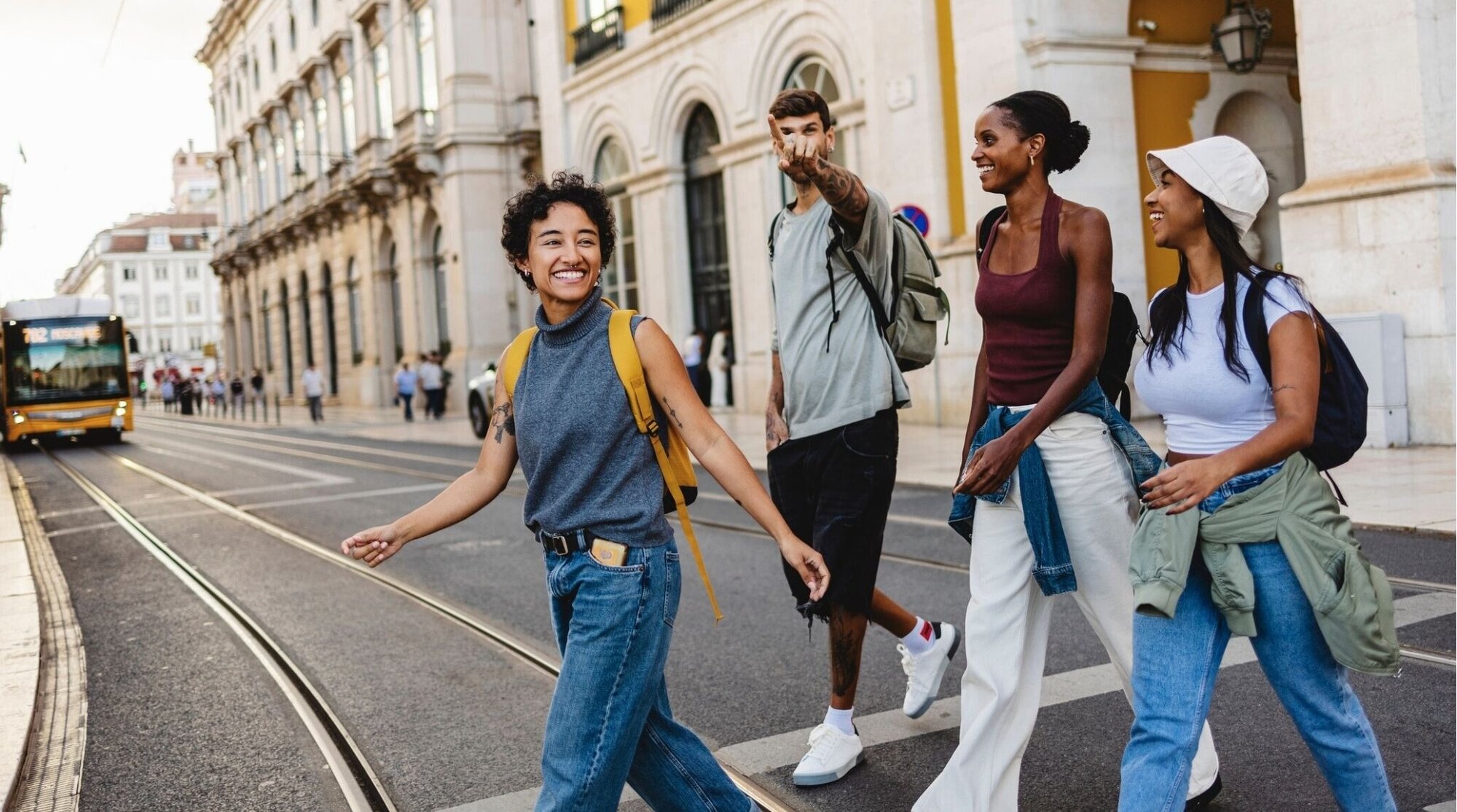 Turistas cruzando la calle en Lisboa junto a un tranvía.