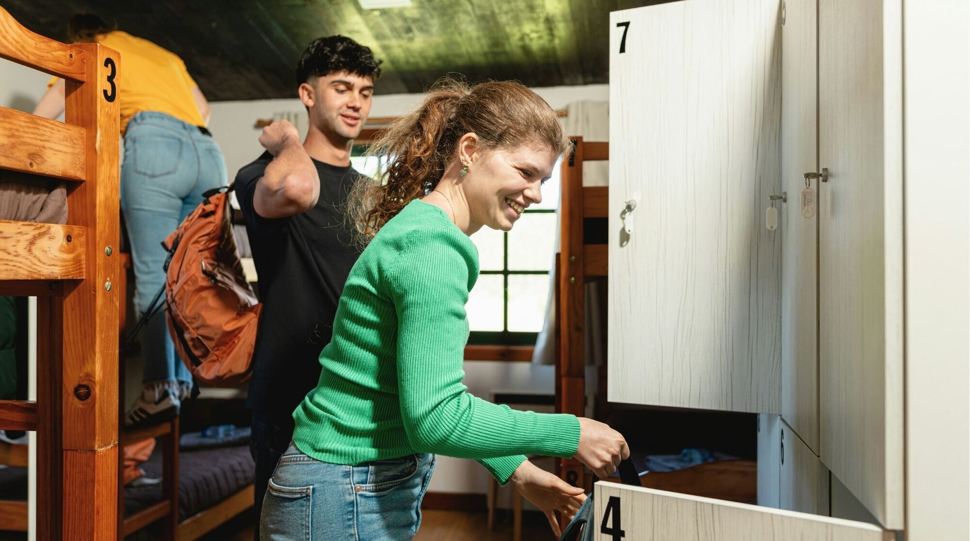 jovem casal se hospedando em hostels em quartos coletivos.