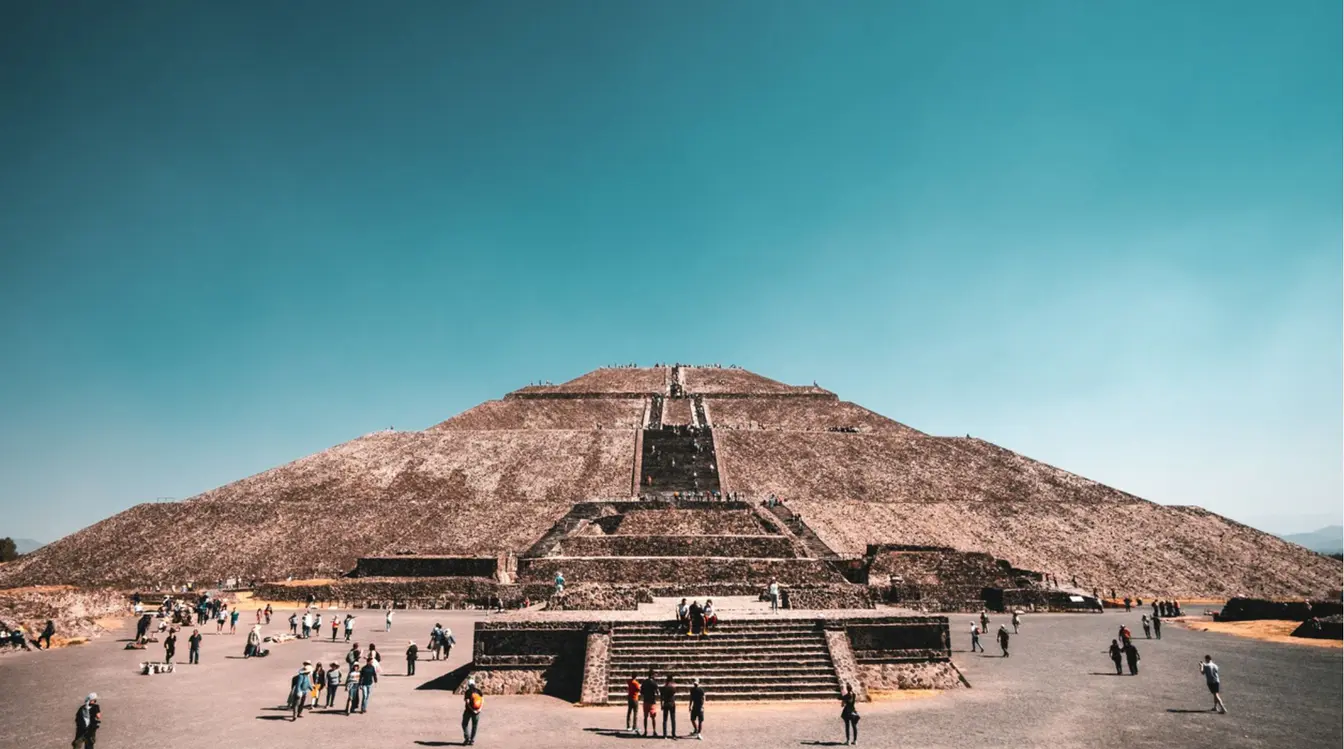 Pirámide del Sol en Teotihuacán vista desde la explanada con visitantes caminando