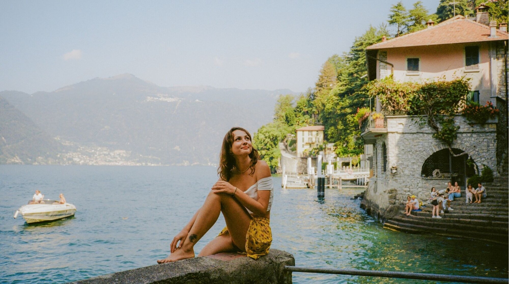 Jovem mulher sentada em mirante próximo ao Lago Como na Itália.