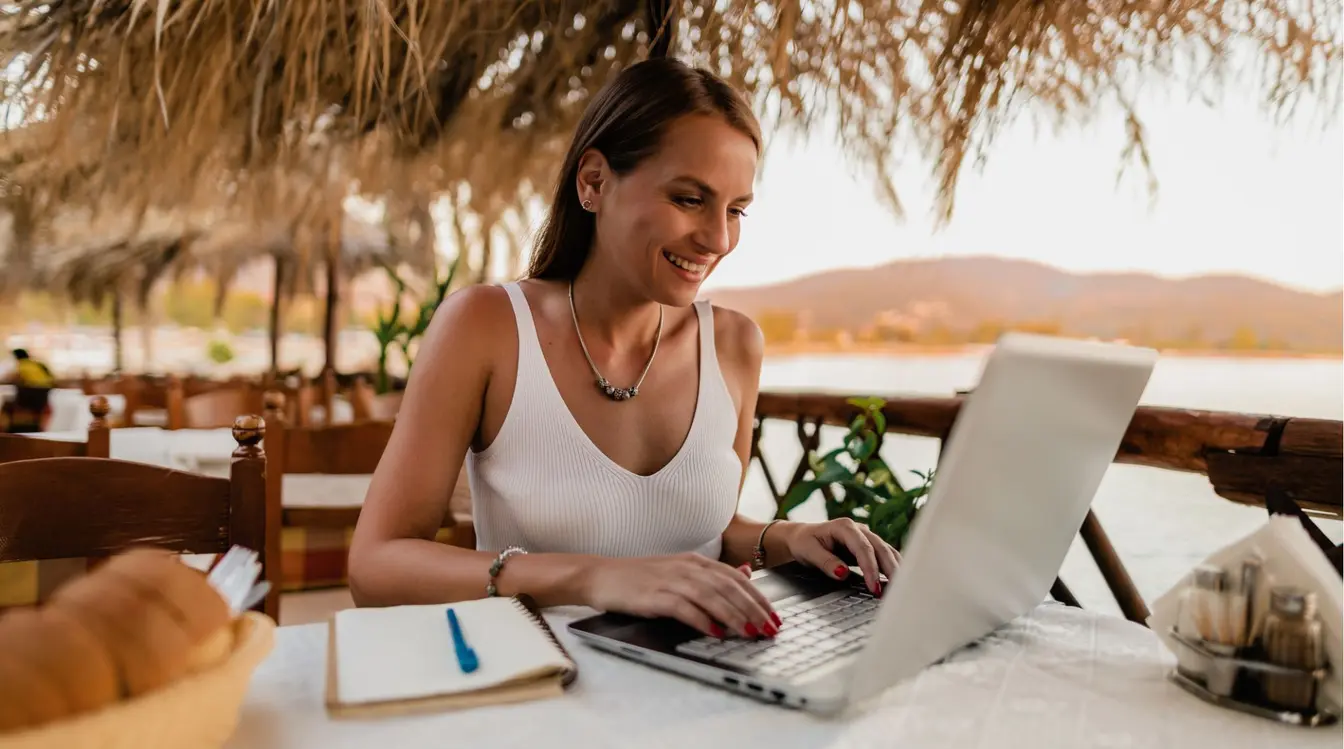Femme utilisant son ordinateur portable dans un restaurant pendant son voyage.