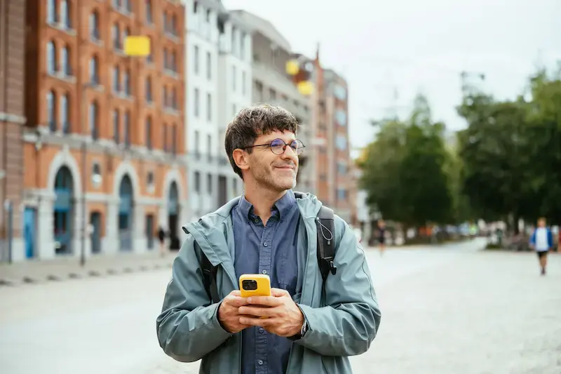 Viajero navegando con datos móviles en su celular durante un viaje al extranjero