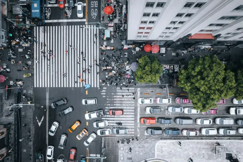 Vista cenital de un cruce peatonal con tráfico y personas caminando en Ciudad de México.