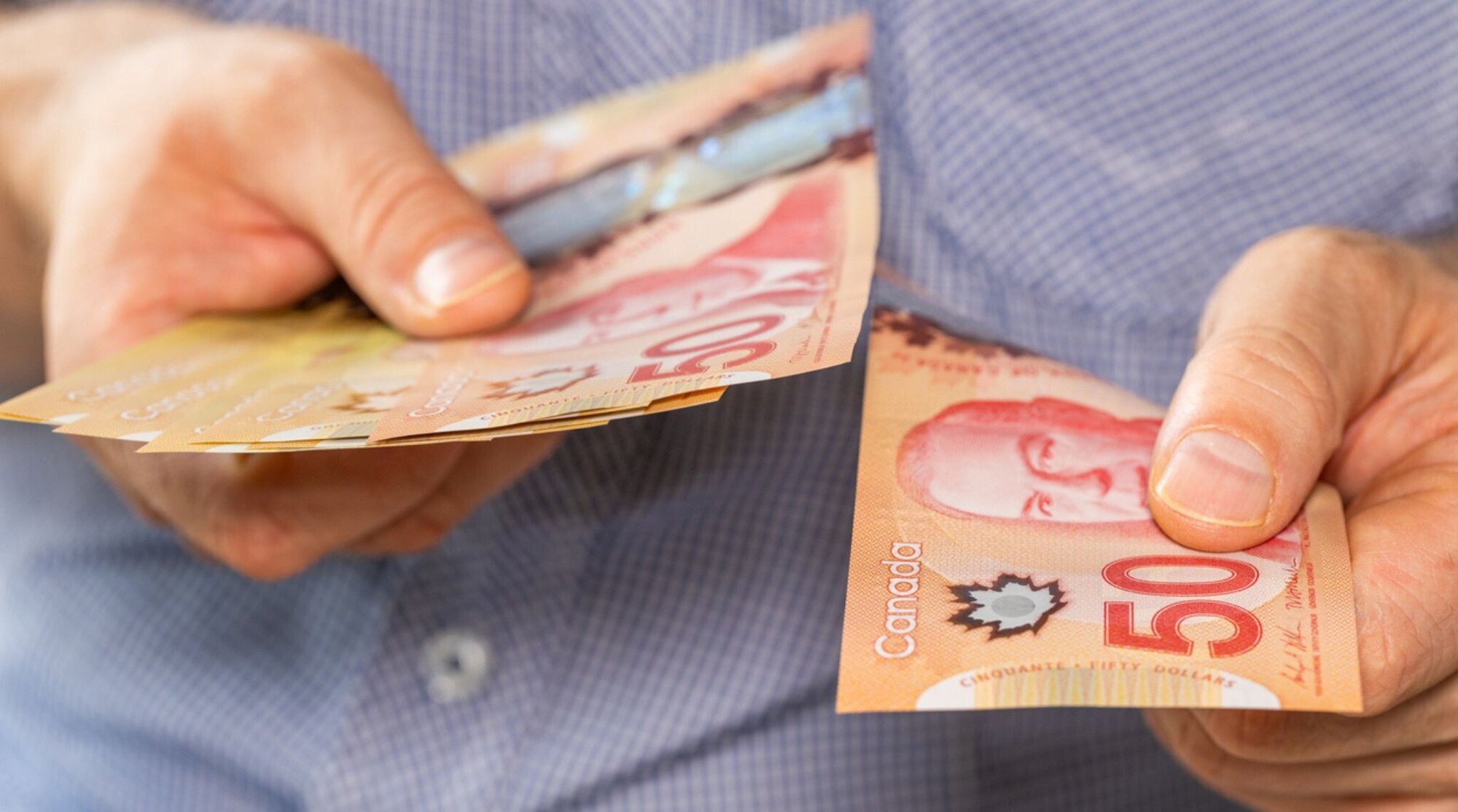 dollars canadiens en billets dans la main