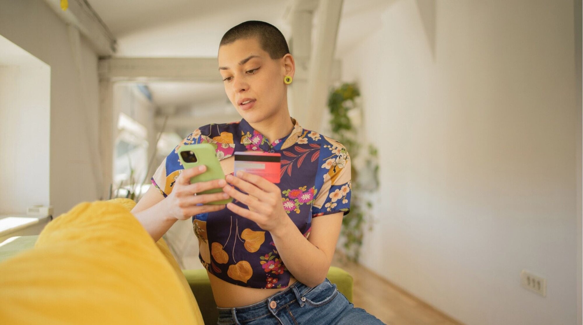 Mujer comprando online con el móvil y tarjetas; cómo encontrar una eSIM más barata paso a paso.