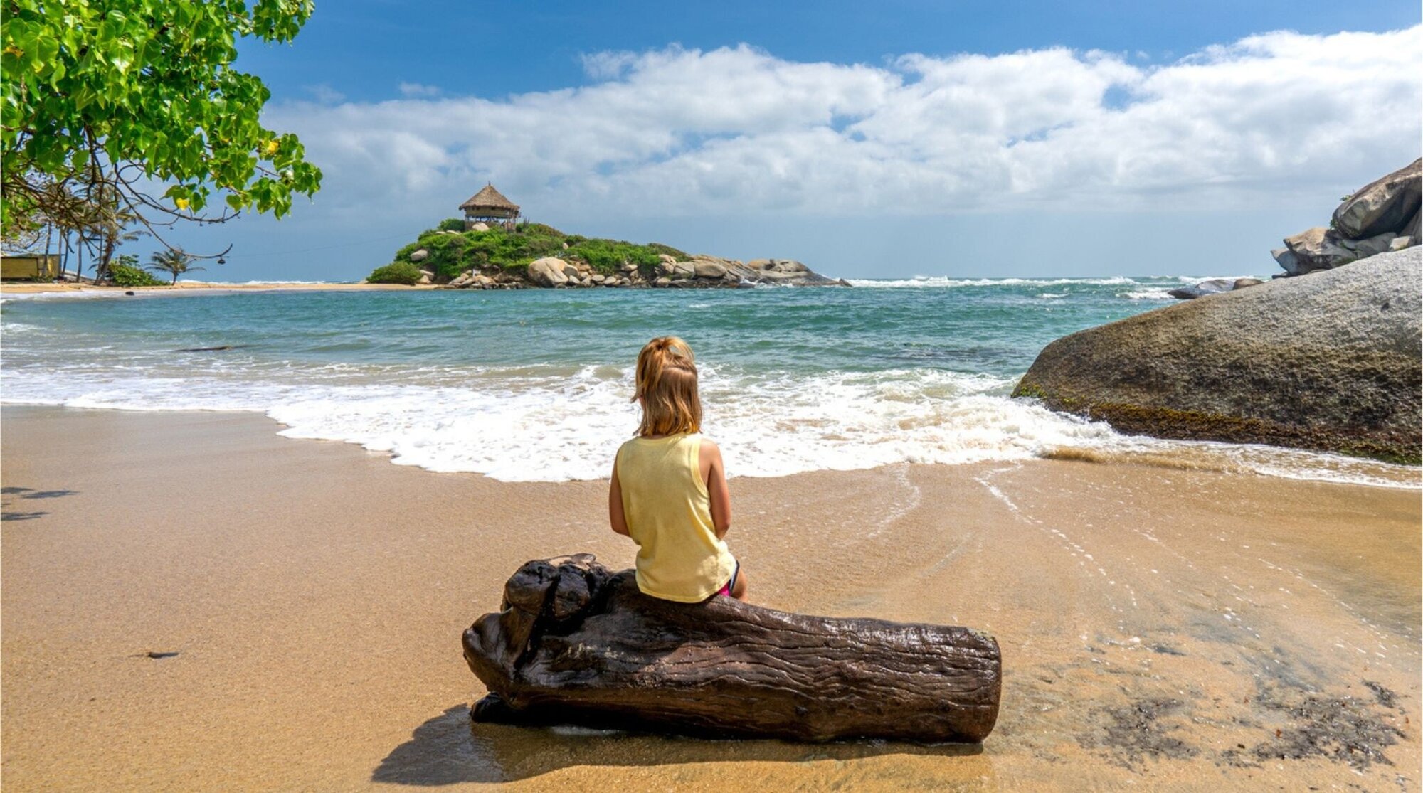 Niña en la playa de Cabo San Juan, Parque Tayrona, con mar turquesa y arena clara.