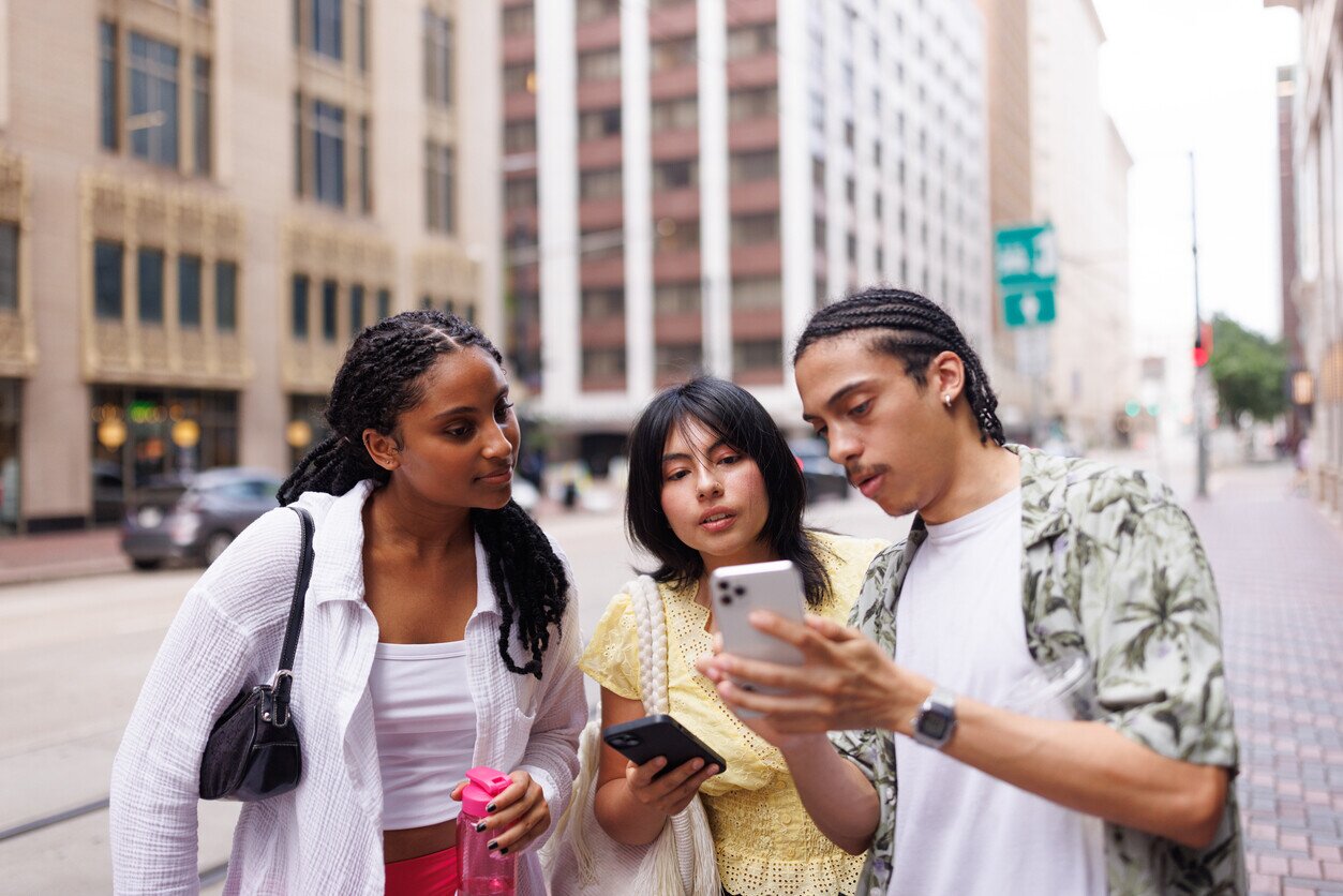 Gruppe an Menschen in den USA mit Internet auf deutschem Handy