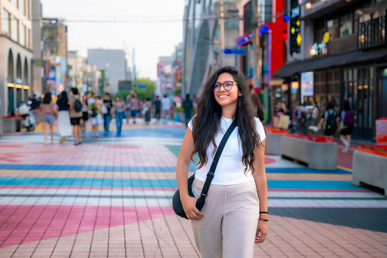 Una persona sonriente caminando por las calles del barrio de Hongdae, en Seúl.