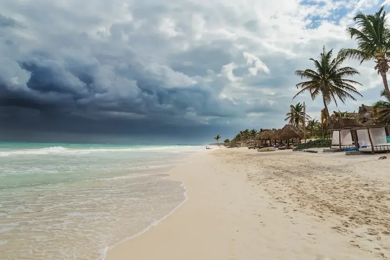 Costa de México en verano con nubes de tormenta al fondo y cielo despejado más cerca de la playa.