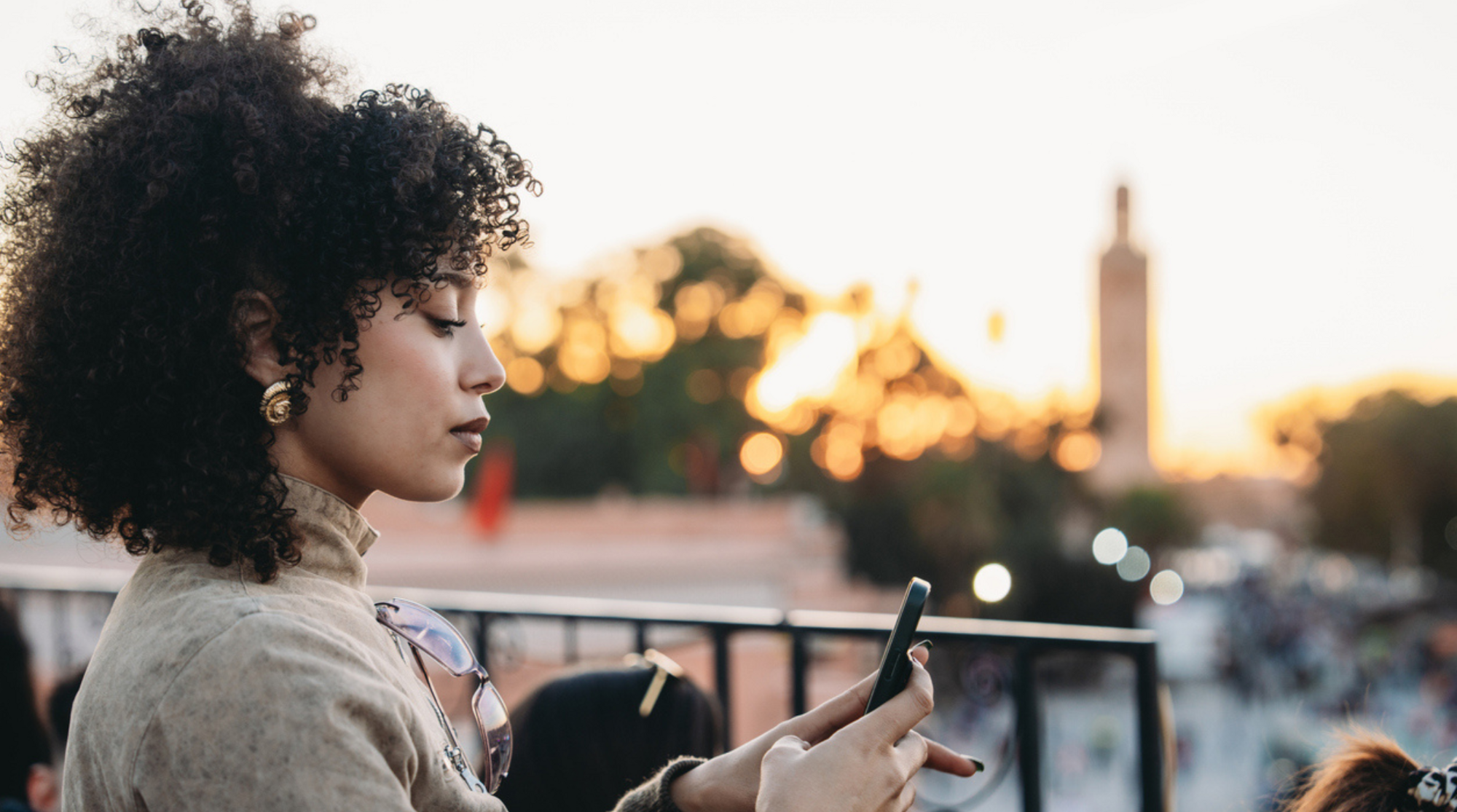 femme tenant son téléphone avec un forfait eSIM illimité au Maroc