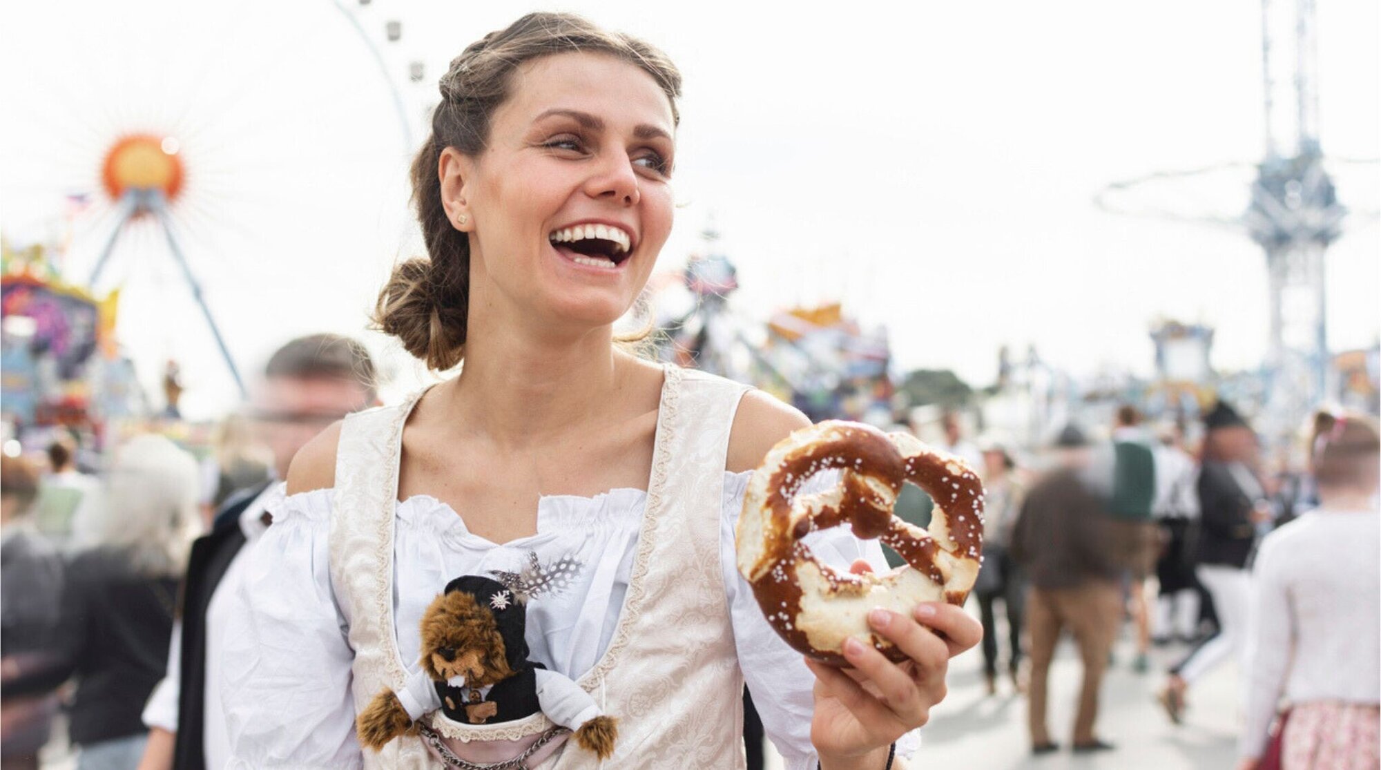 Jovem alemã comendo pretzels na Oktoberfest.