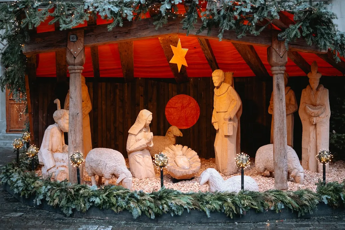 クリスマスシーズンの中庭に置かれたクリスマス装飾が施されたキリスト降誕のシーンを表した木彫りの人形