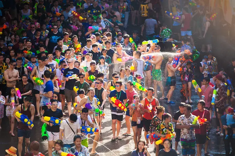 Crowds of people with water guns having a water fight in the street during Songkran Festival in Bangkok.