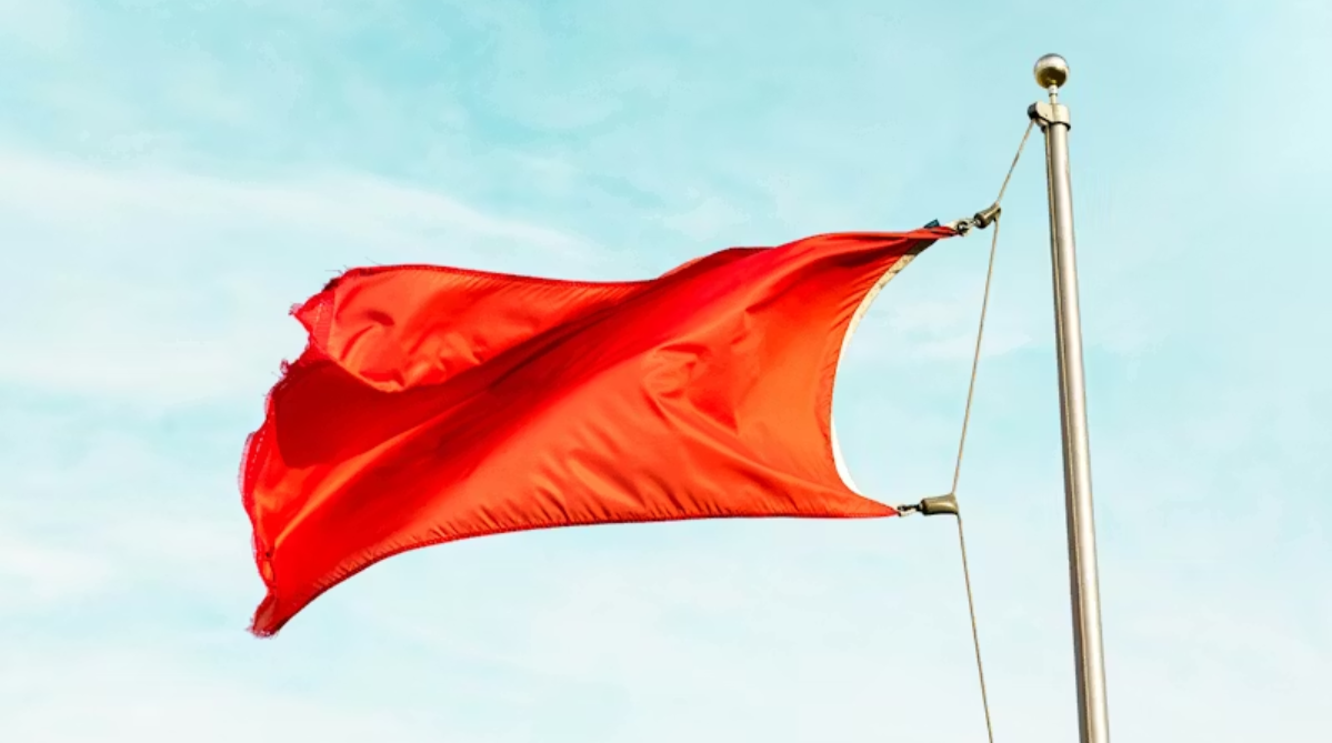 A red flag at the top of the flagpole