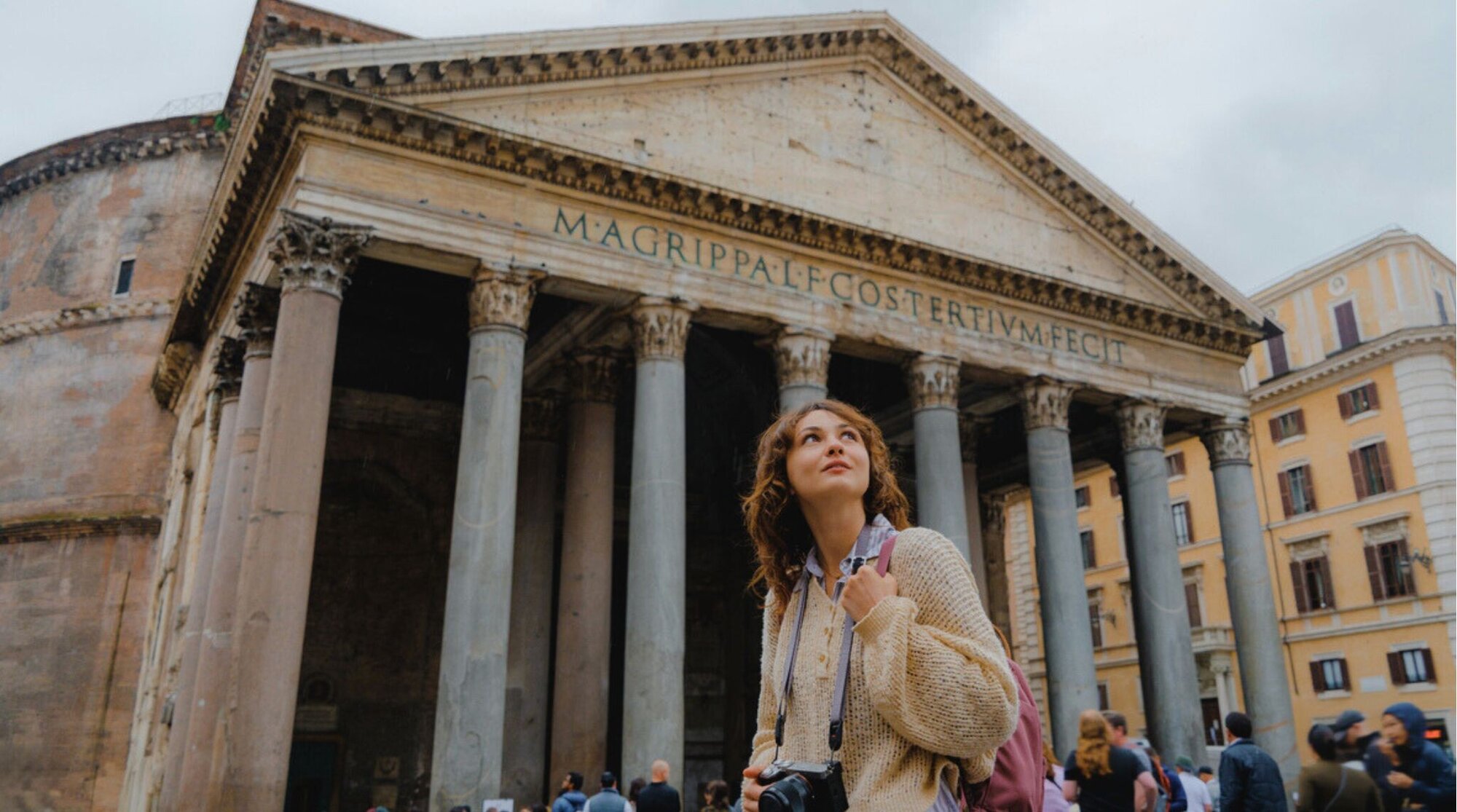 Mulher alegre caminhando pelas ruas de Roma próxima ao Panteão, apreciando a arquitetura durante sua visita.